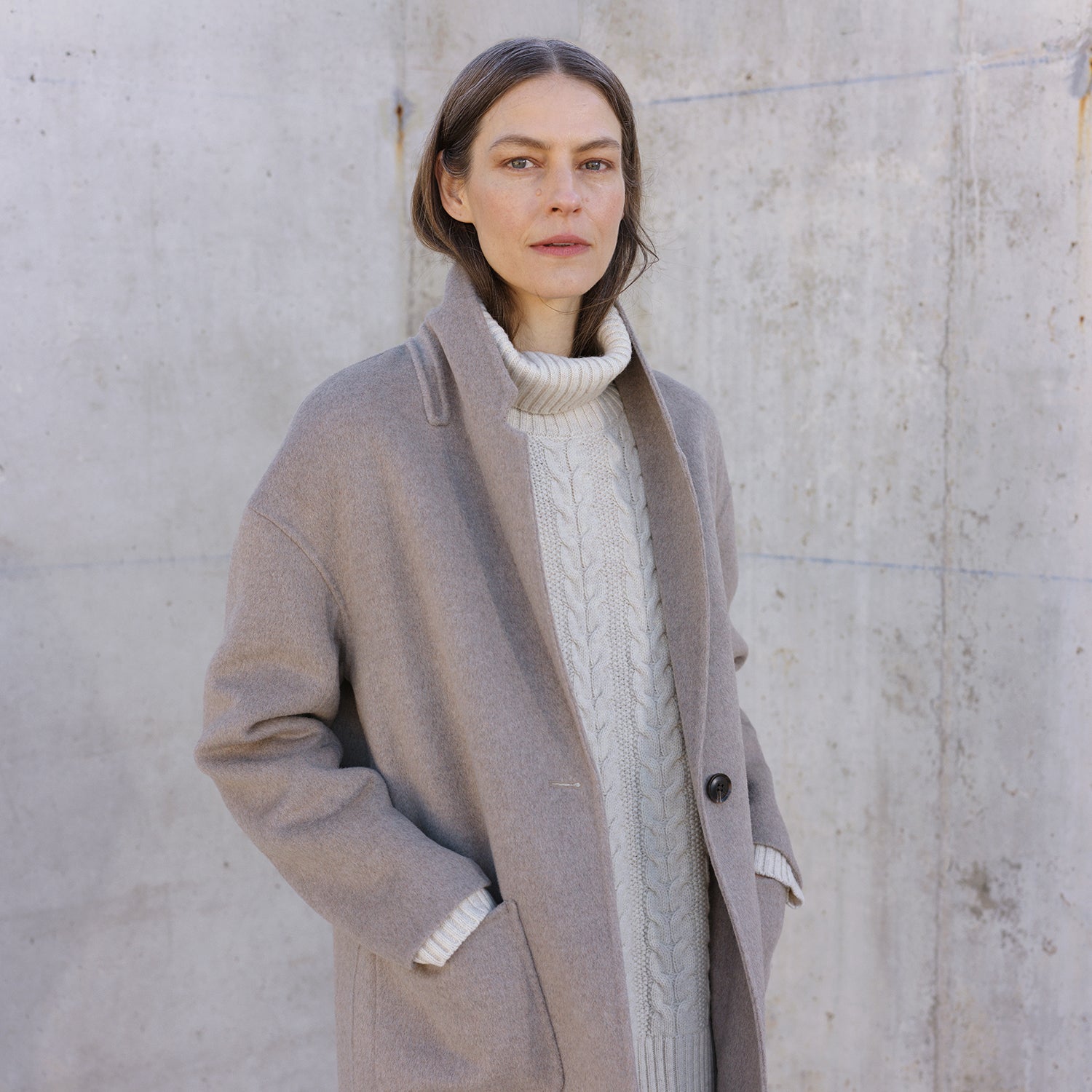 Nanso women's stylish and timeless beige YLLE wool coat. On a model from the front with knitted shirt