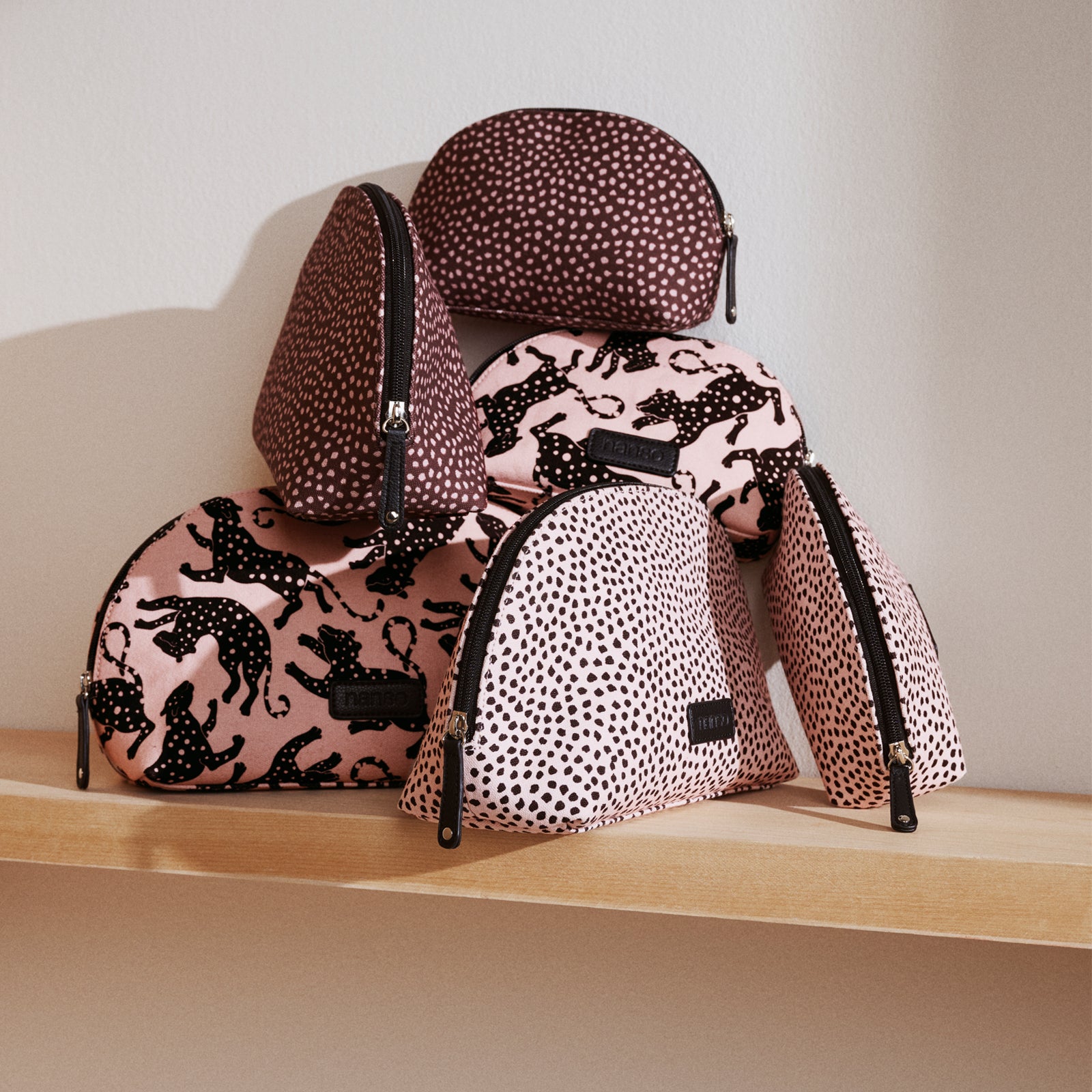 Set of Muru and Leonora cosmetics bags on a wooden surface.