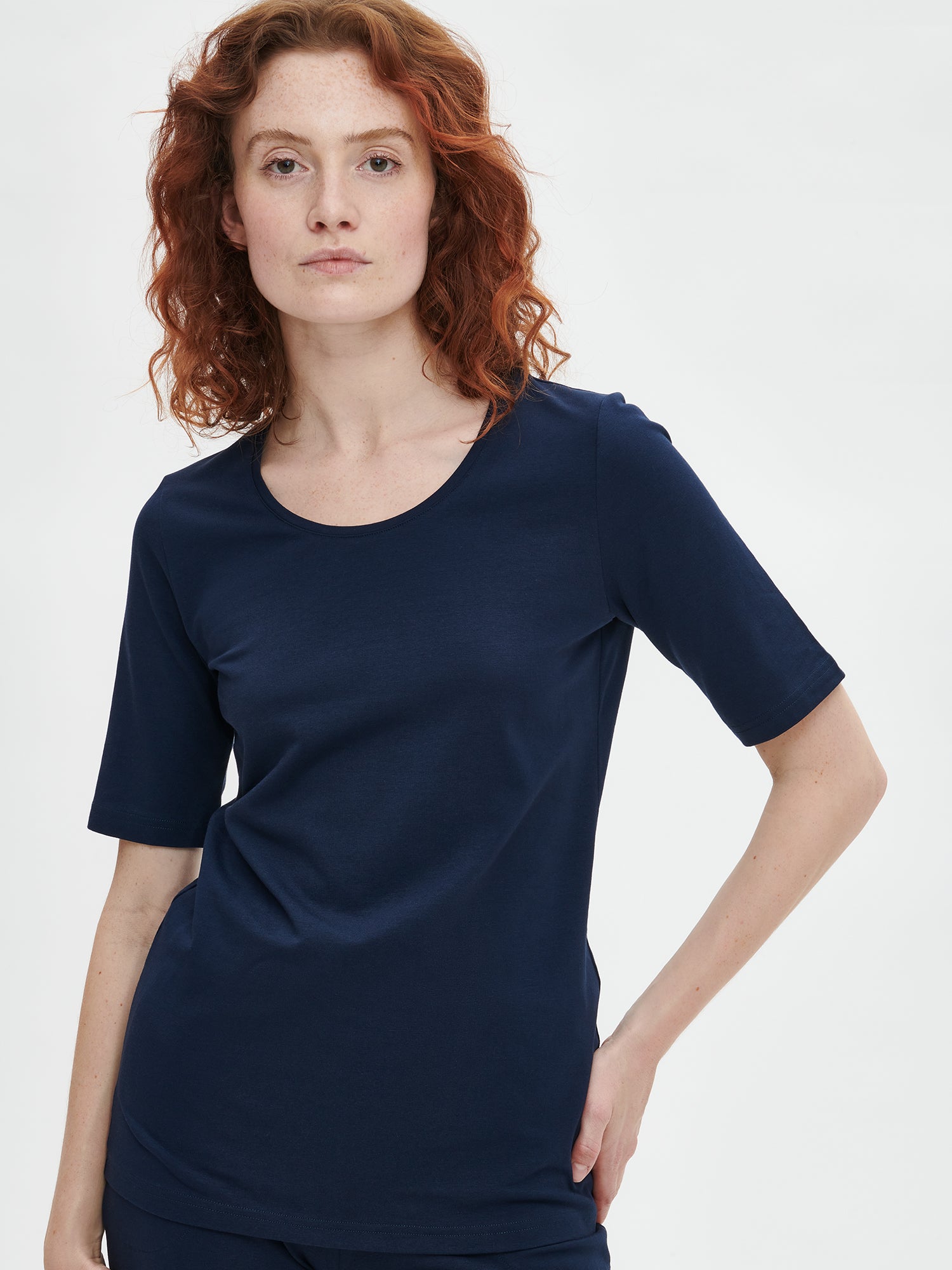 Ladies' Basic 7/8 dark blue jersey bottoms with a comfortable elastic band at the waist, side pockets and small side slits at leg openings. On a model pictured from the front with a dark blue t-shirt, close-up.