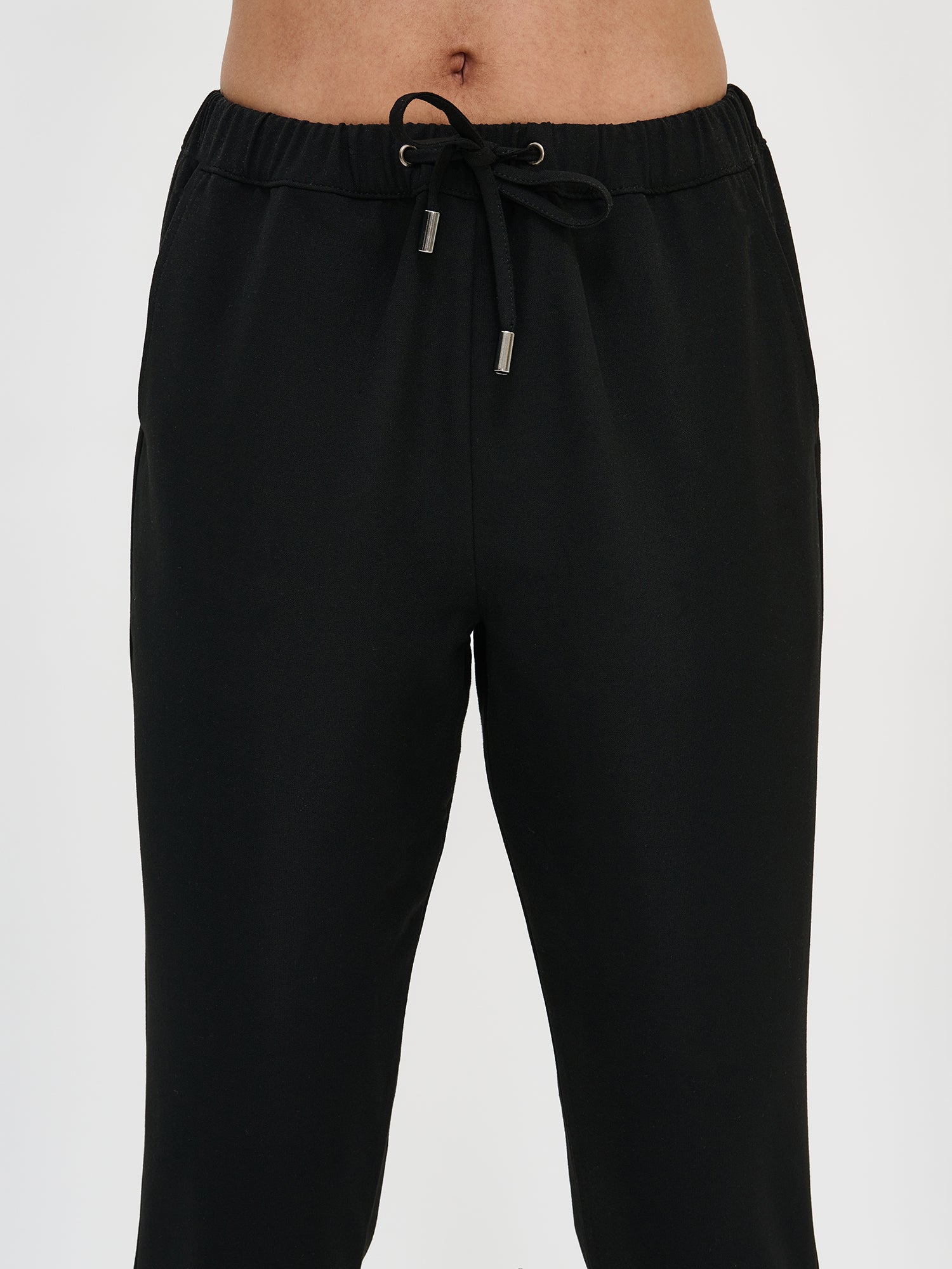 Nanso women's black Joggeri trousers with pockets and elastic waistband, close-up.