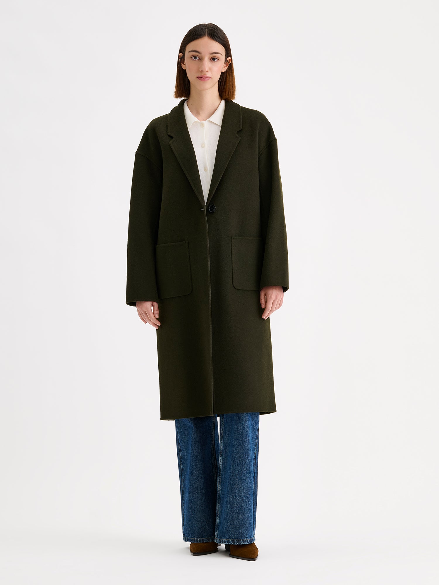 Nanso women's stylish and timeless olive green YLLE wool coat on a model with a white collared cardigan and jeans