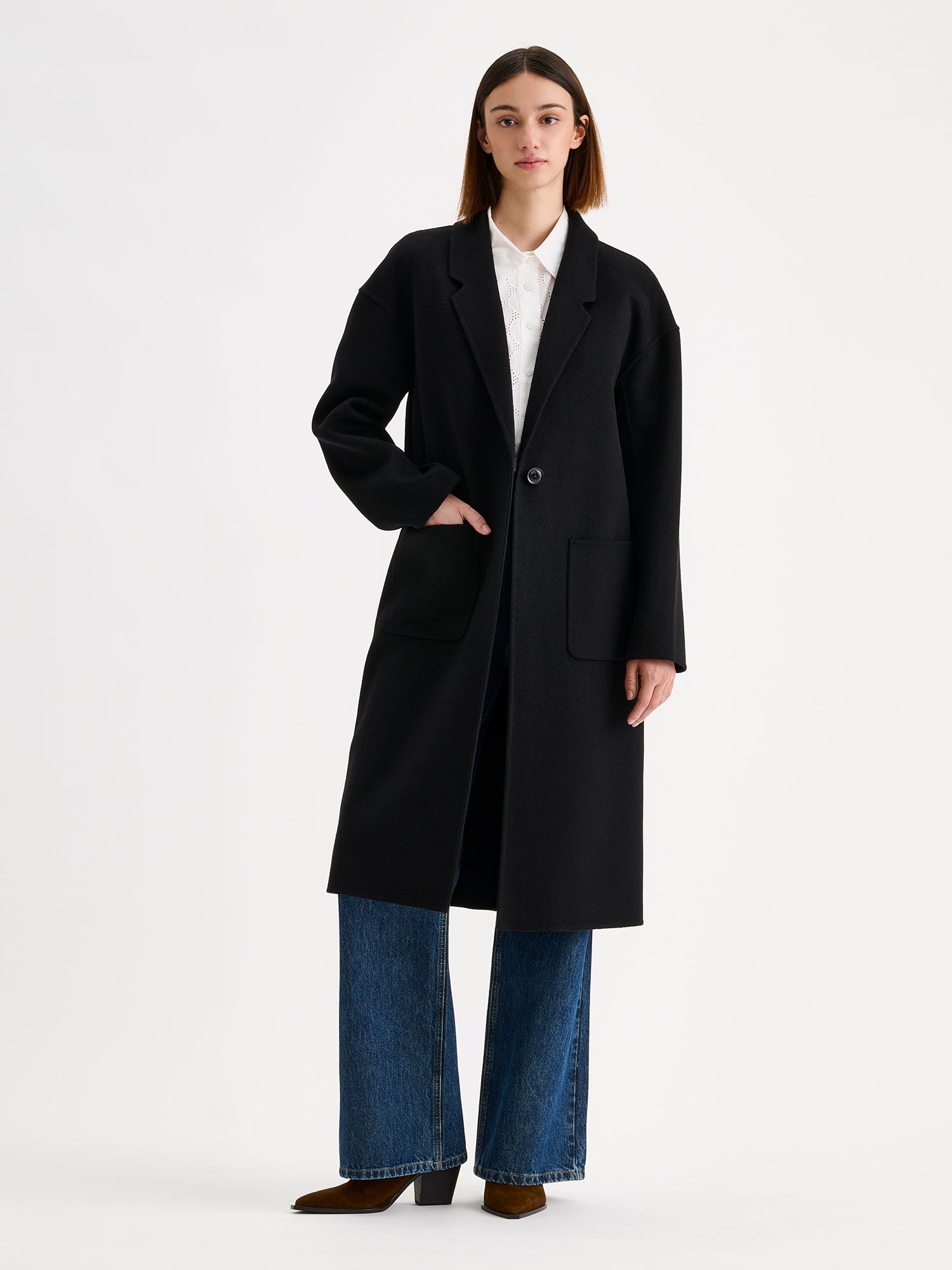 Nanso women's stylish and timeless black YLLE wool coat on a model with jeans and a white cardigan | S - 173cm