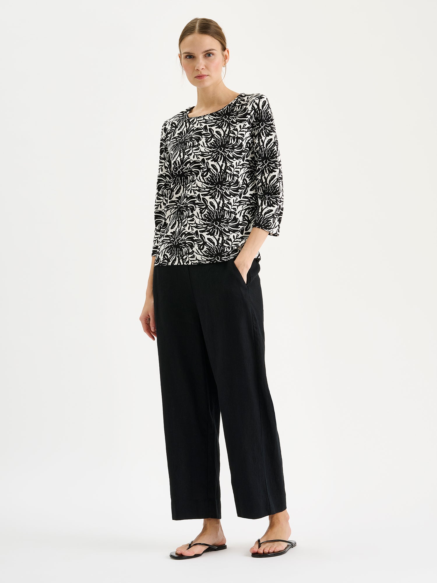 Nanso SAARI linen culottes with elasticated waist and side pockets in a sophisticated black shade on a model with a print blouse.