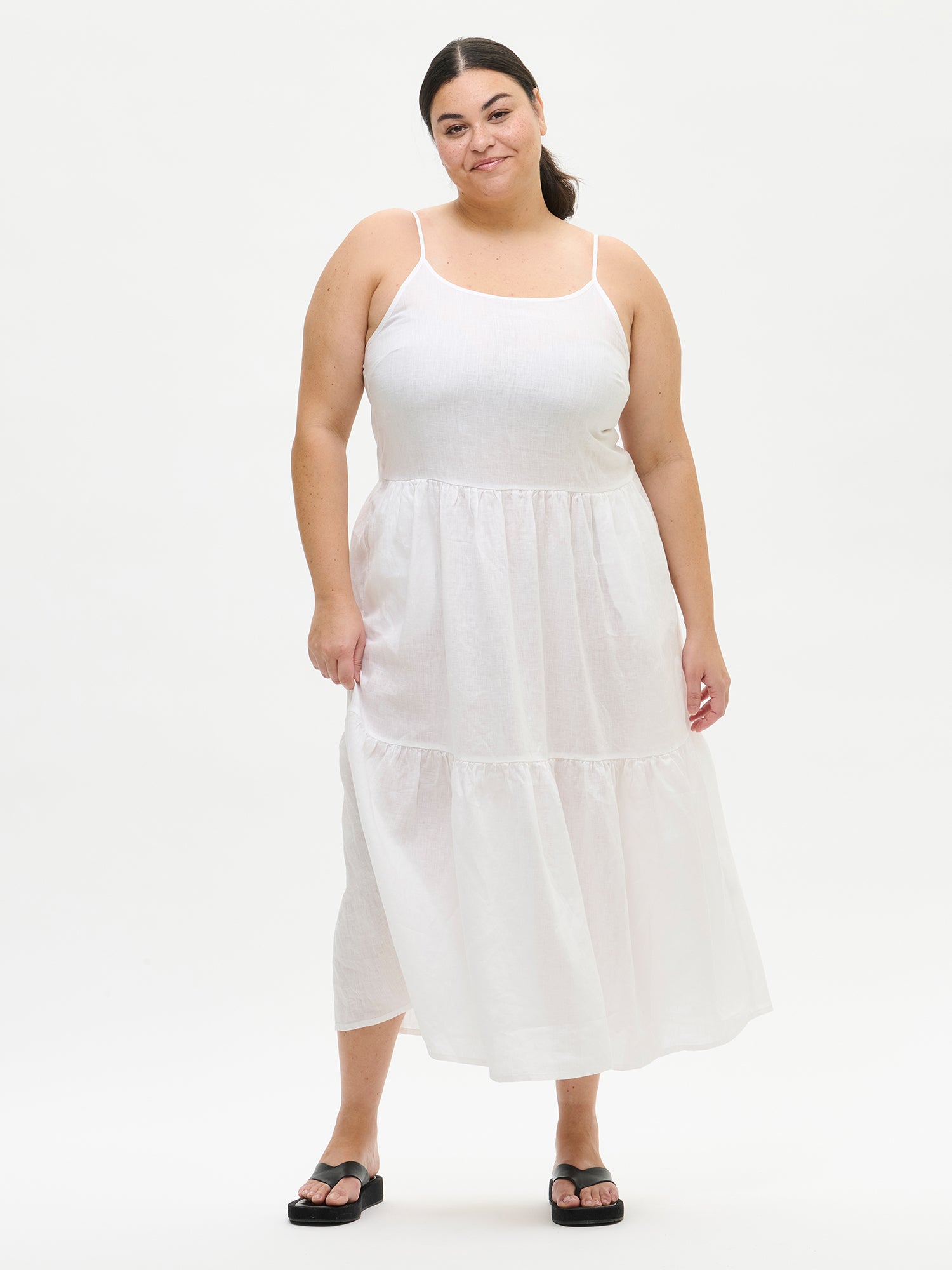 Woman wearing a white sleeveless dress on a white background