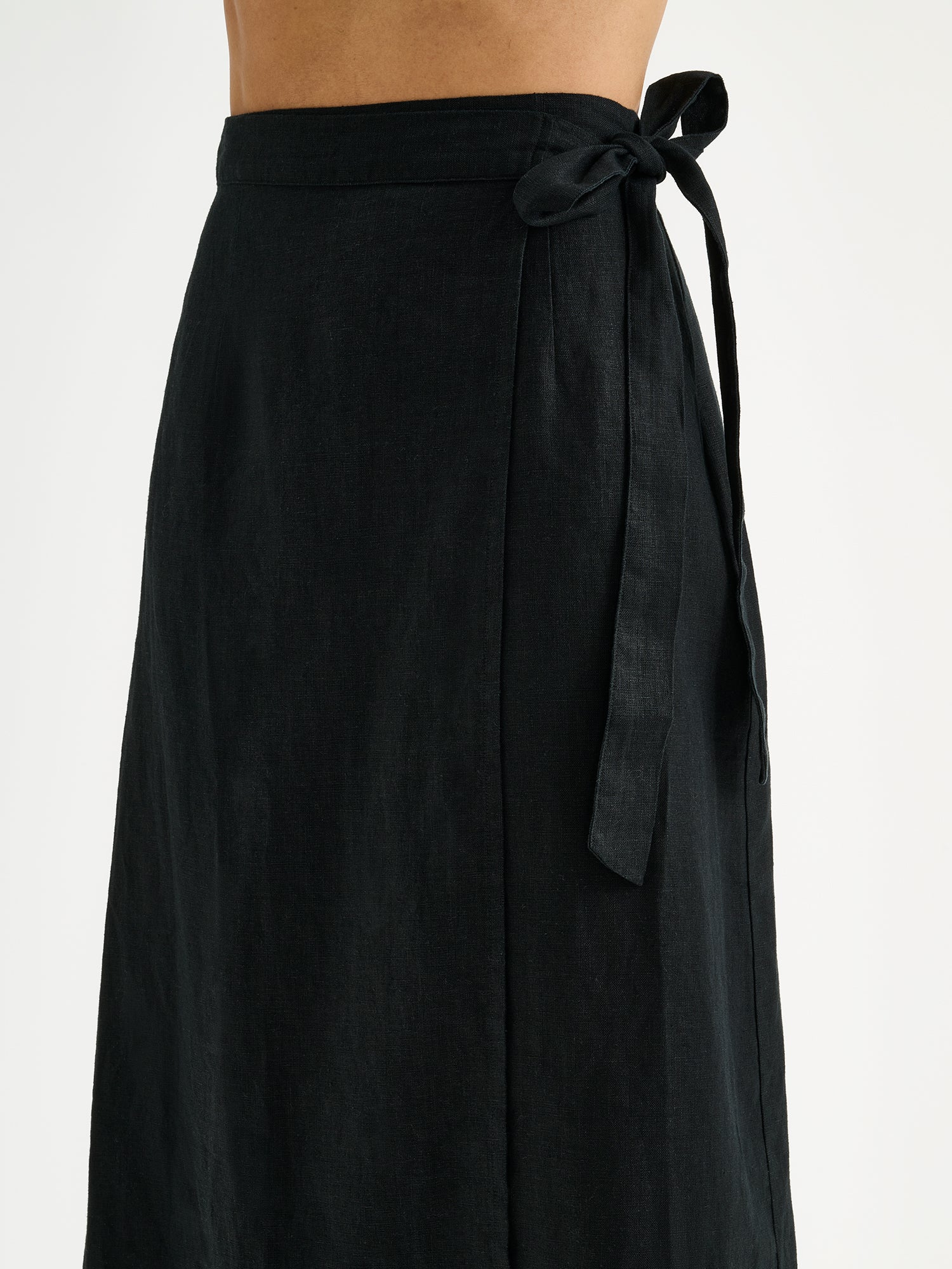 Nanso women's elegant black wrap-style Liine linen skirt on a model, close-up.