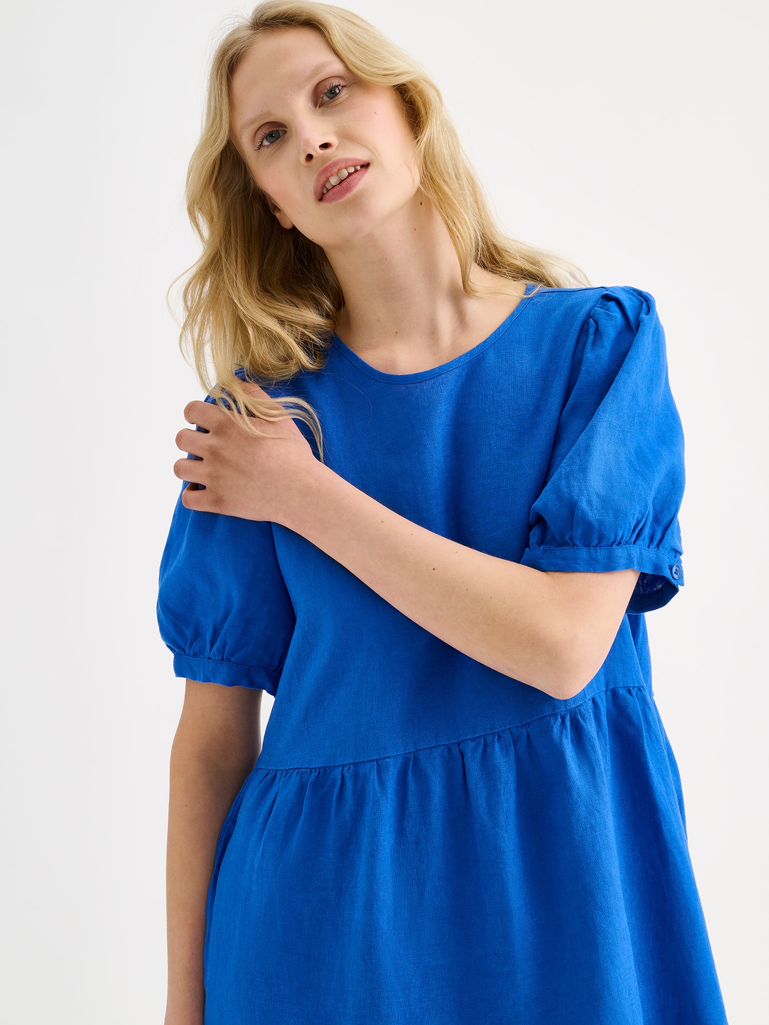 The Sarastus long blue dress for women is made of high-quality, durable, and breathable woven linen fabric, on a model close-up.
