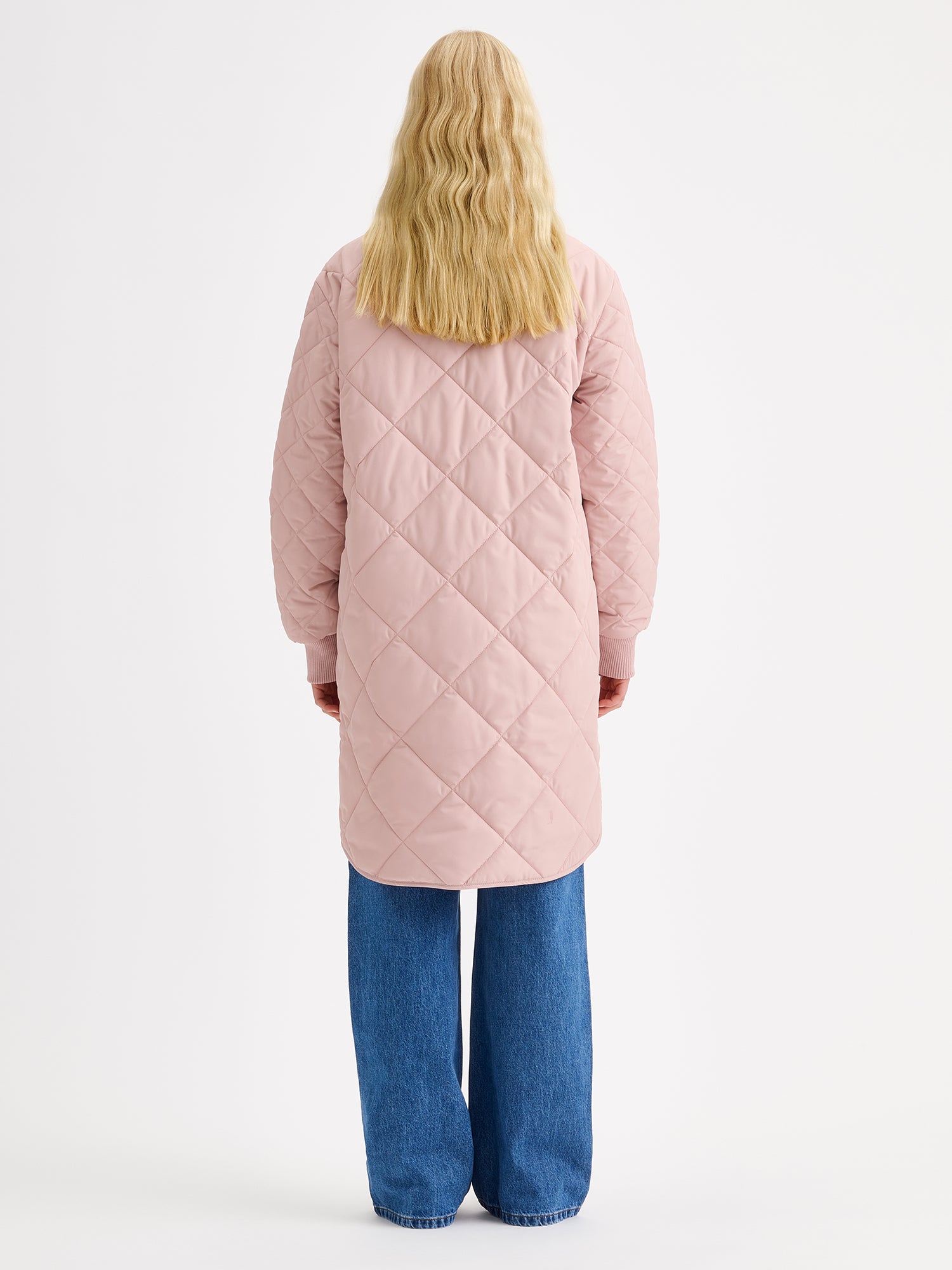 Nanso women's casual Midi quilted coat in dark blue features lightweight padding, ribbed knit detailing at the neckline and cuffs, snap closures and front pockets. Pictured on a model, from the back.