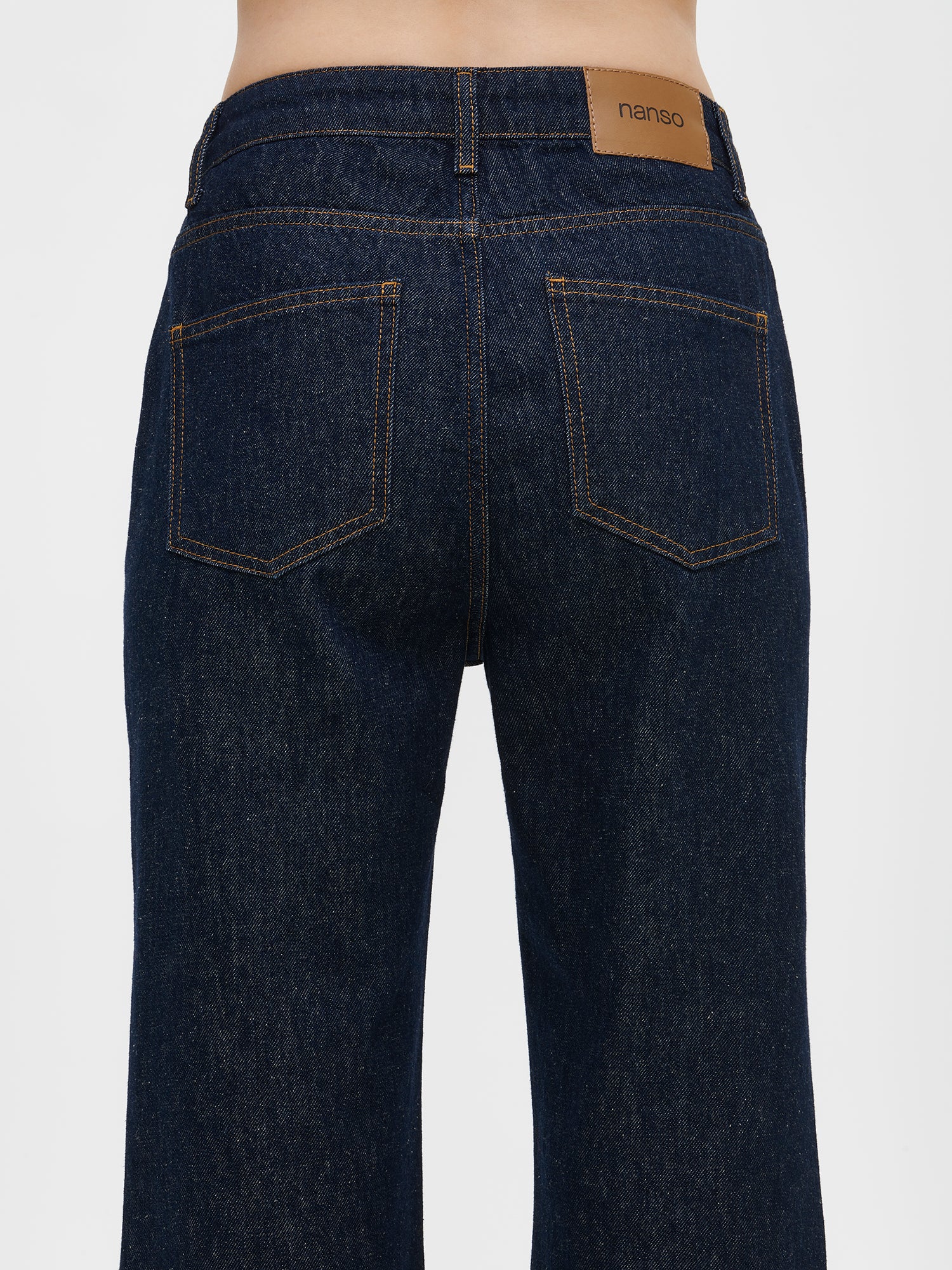 Nanso women’s relaxed dark blue Suora jeans with a regular waist, on a model, close-up from the back side. Straight-leg, full-length denim.
