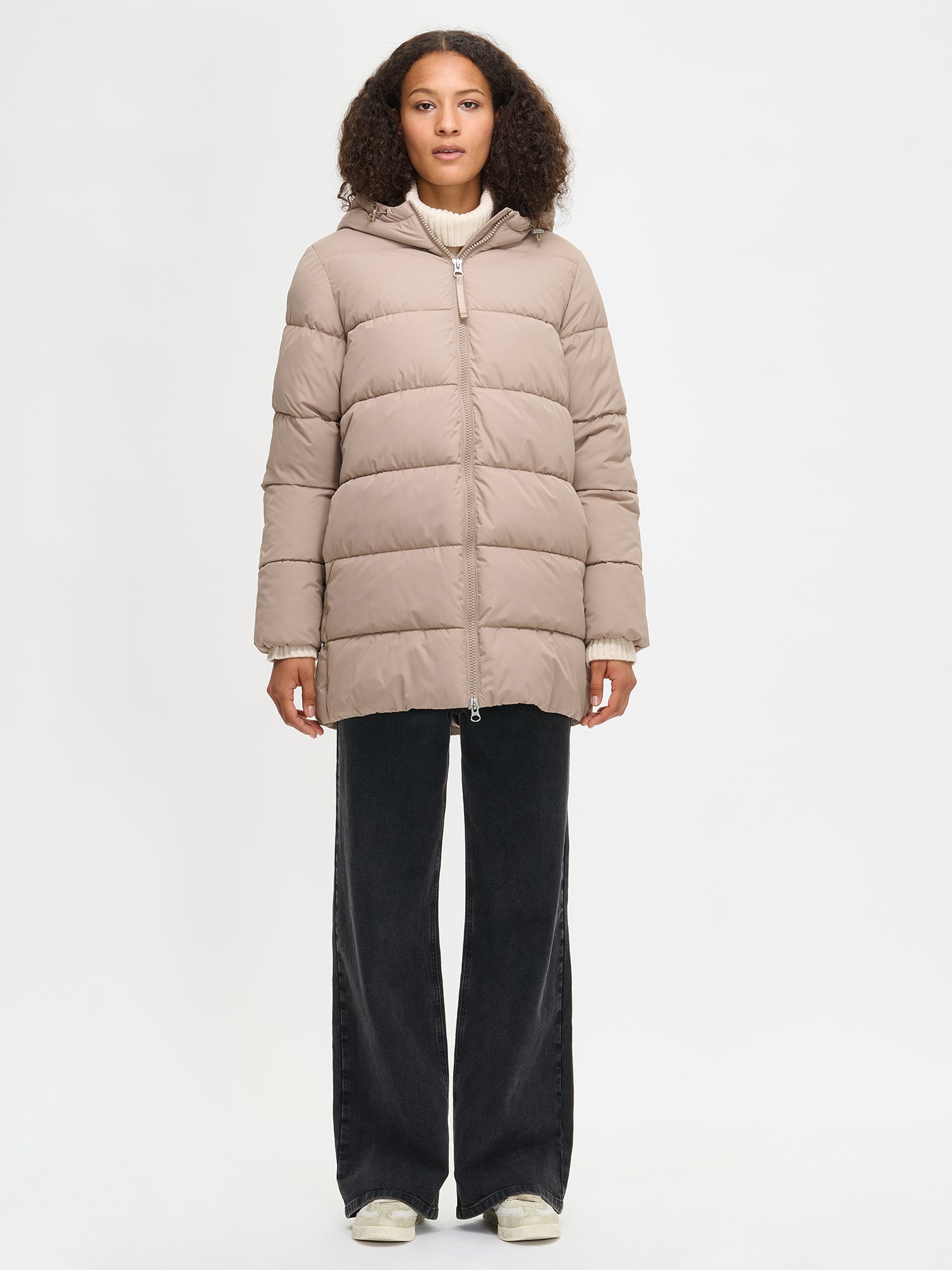 The beige Lumi padded coat provides warmth with its soft, lightweight padding and generous fit. worn by a model in size S.