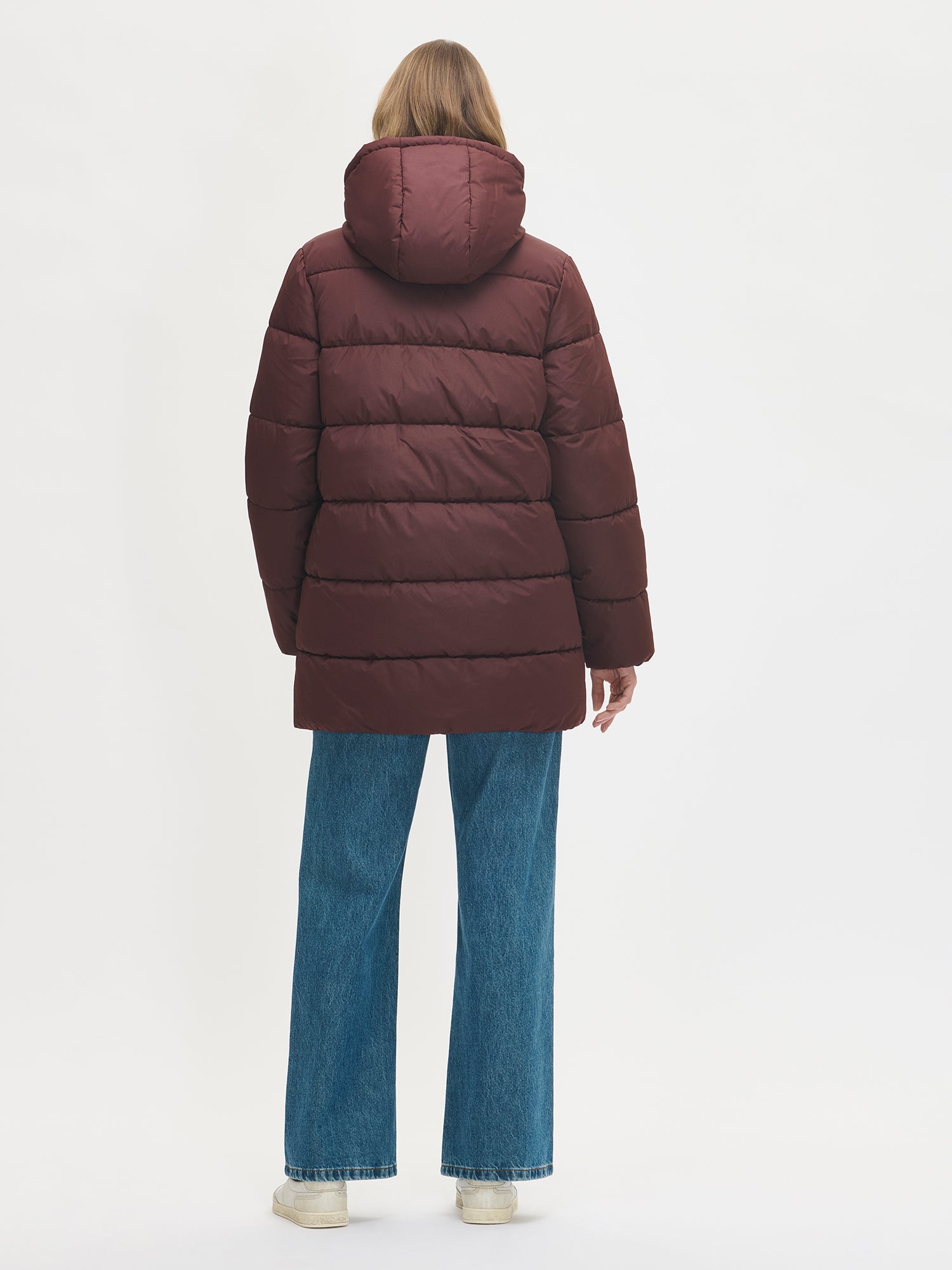 The dark brown Lumi padded coat provides warmth with its soft, lightweight padding and generous fit. From the back.