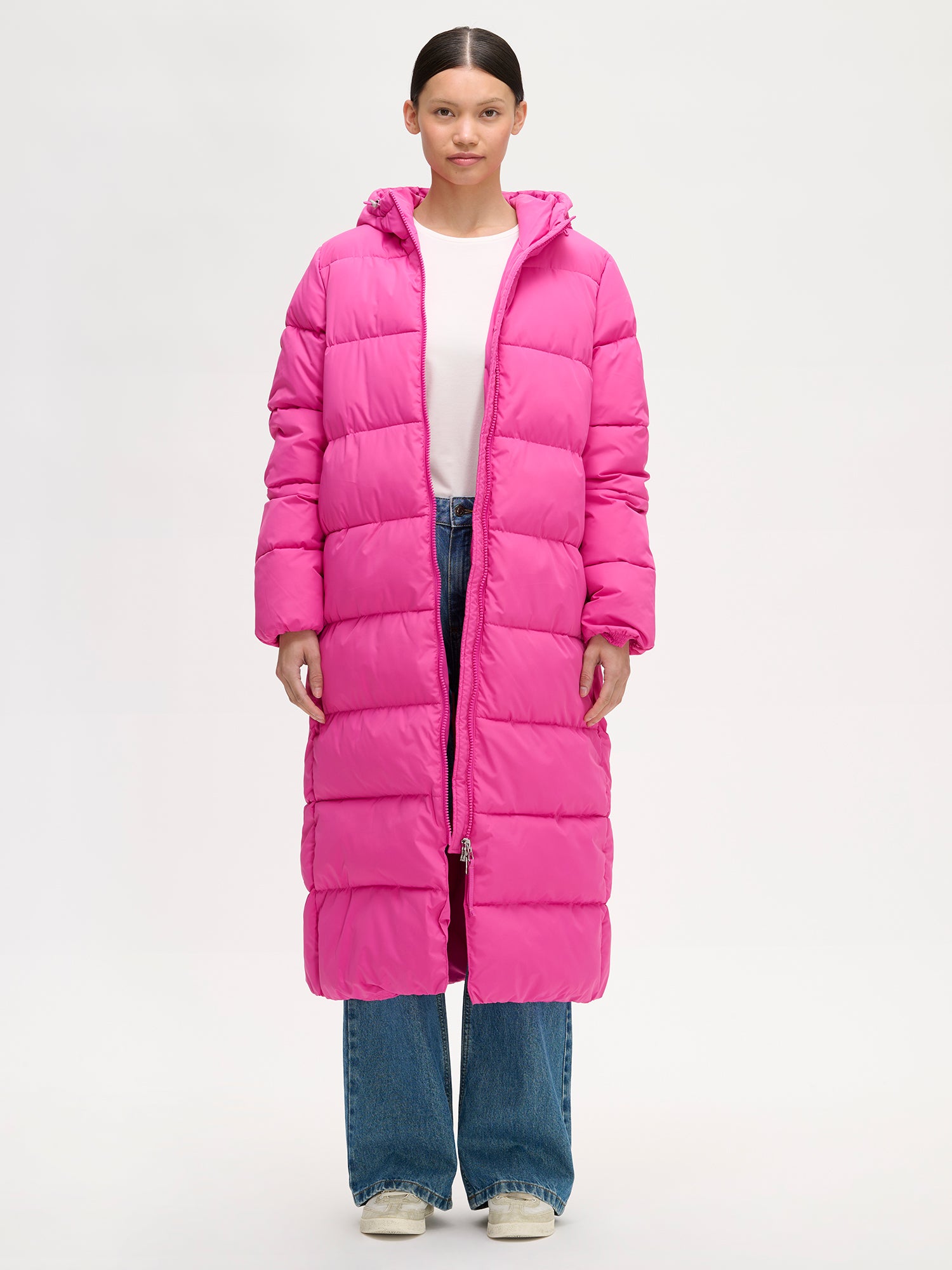 Nanso women´s Lumi Long Pink Puffer Coat in pink offers cozy warmth with its lightweight, puffy insulation. Worn by a model jacket open.
