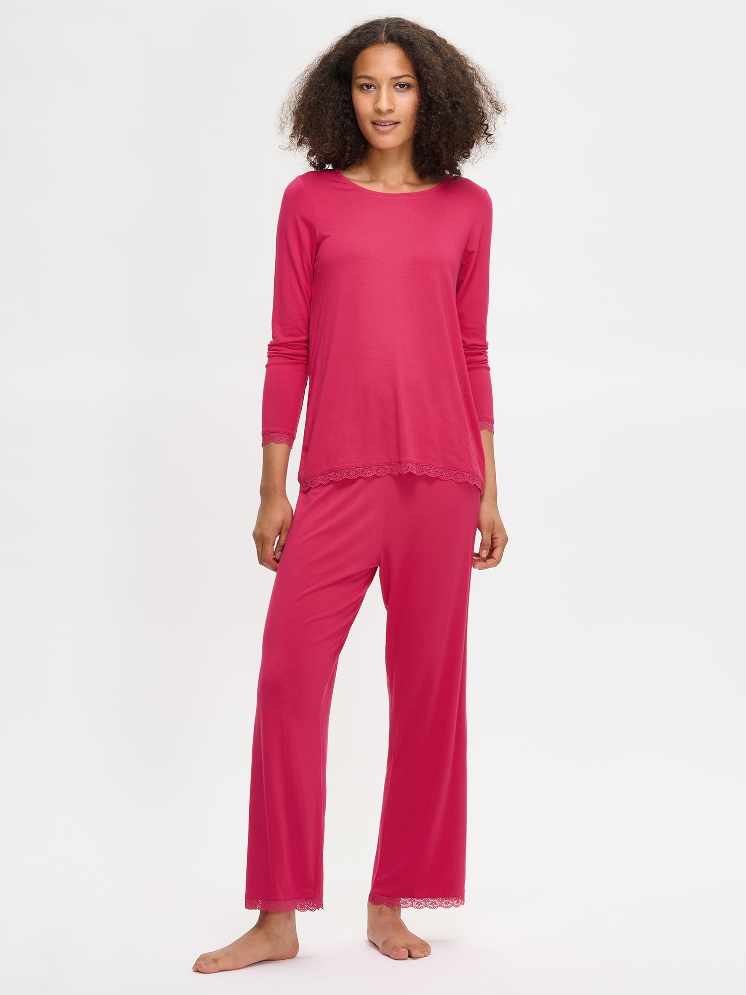 Pink Pitsi shirt with long sleeves and a round neckline on a model. The model wears same colored Pitsi pants as well.