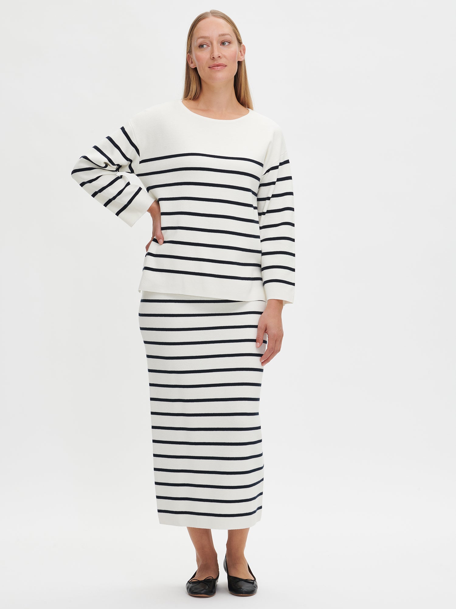 Woman wearing a black and white striped dress on a white background