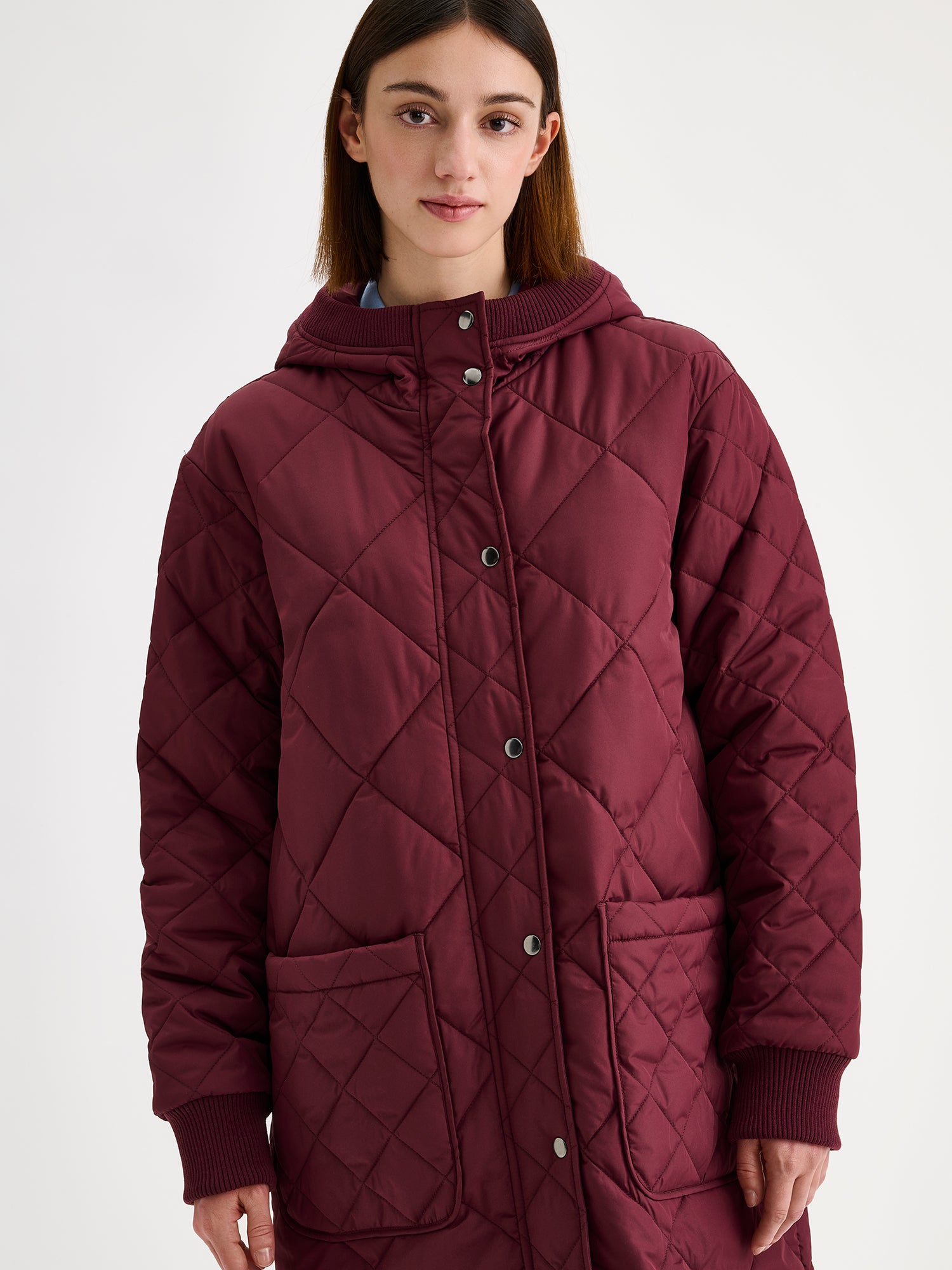 Nanso women's casual winered Maxi quilted coat with light padding and a cozy hood, on a model close-up