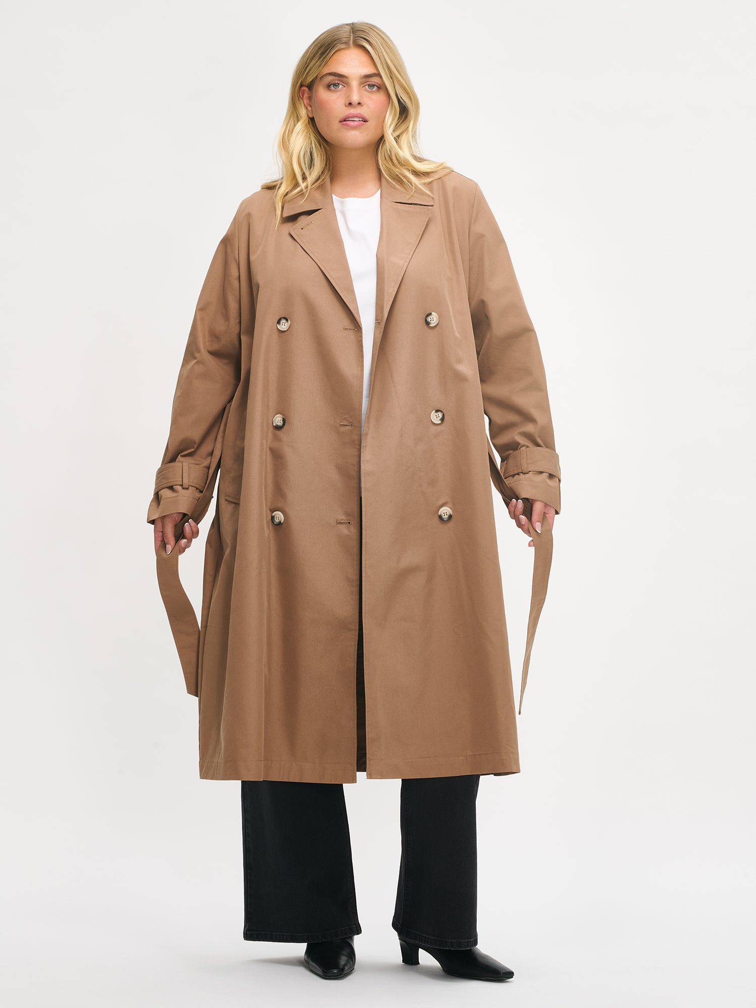 Woman wearing a brown trench coat on a white background
