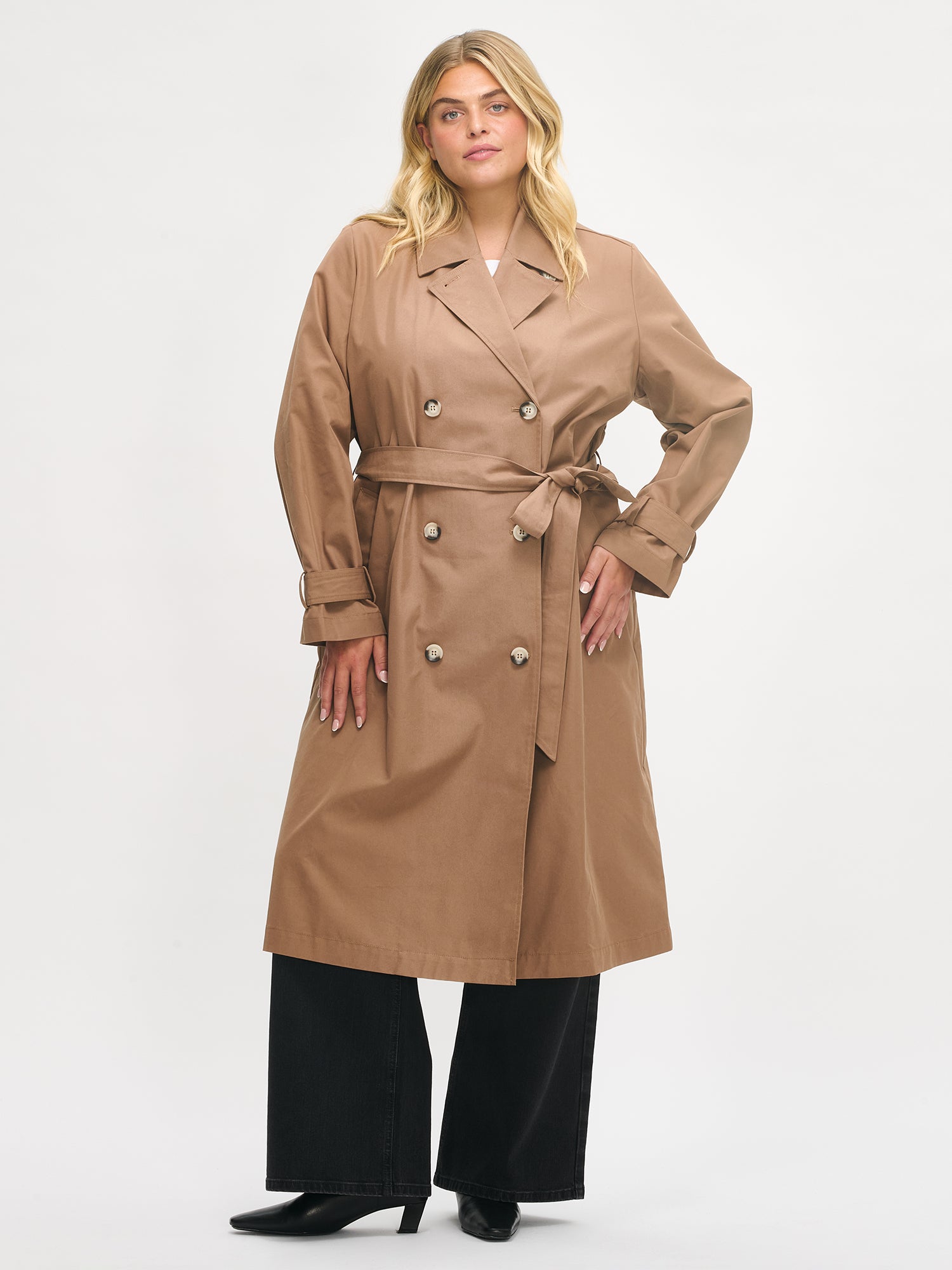 Woman wearing a brown trench coat on a white background