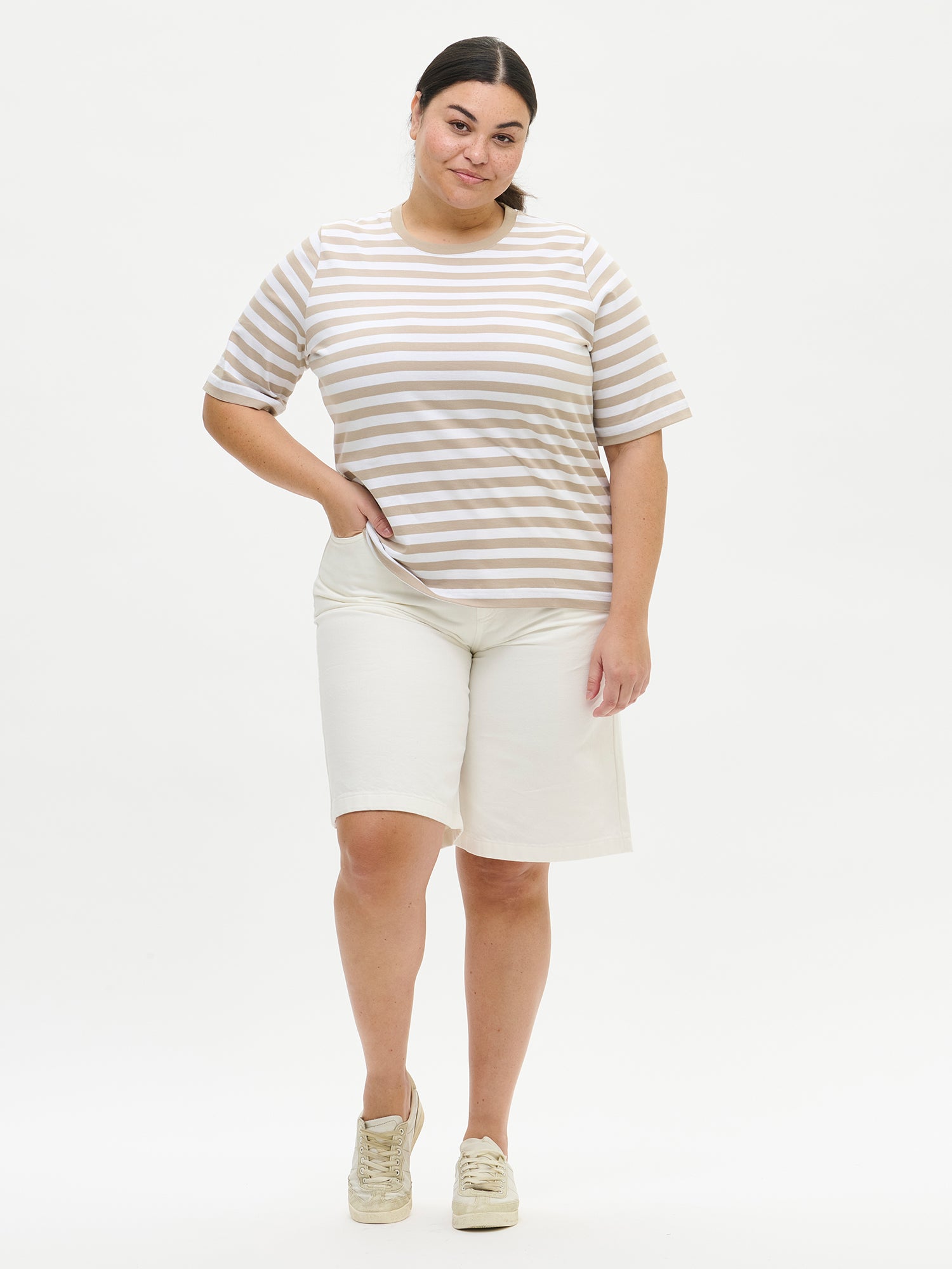 This striped beige and white Raita Normi t-shirt for women is a comfortable everyday classic, perfect for wearing day after day. Worn by a model in size XL from the front.