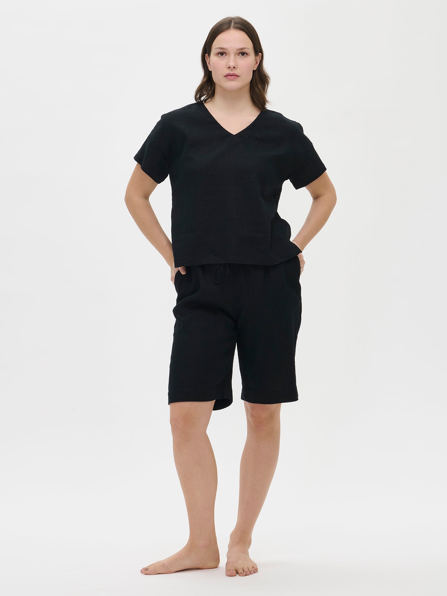 Nanso women's black solid Sarastus linen shirt for relaxed lounging, pictured on a model with black shorts.