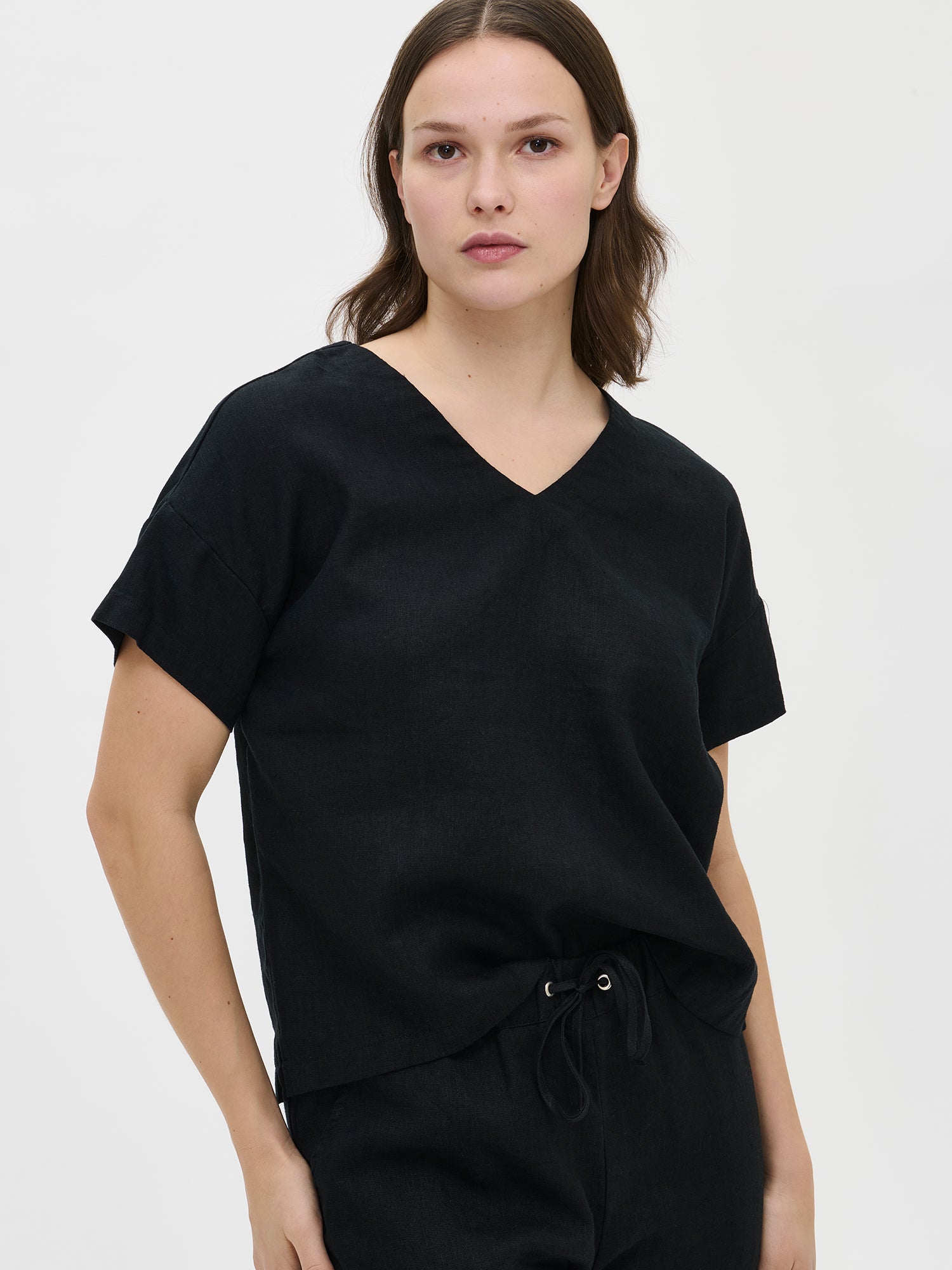 Nanso women's black solid Sarastus linen shirt for relaxed lounging, pictured on a model with black shorts, close-up.