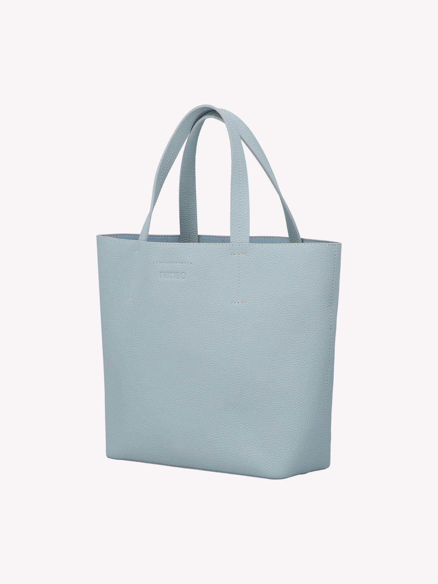 Nanso elegant light blue Naru Tote leather bag. The Naru Tote features both short carry handles and a longer, adjustable and detachable shoulder strap. Product picture from the front without the crossbody strap.