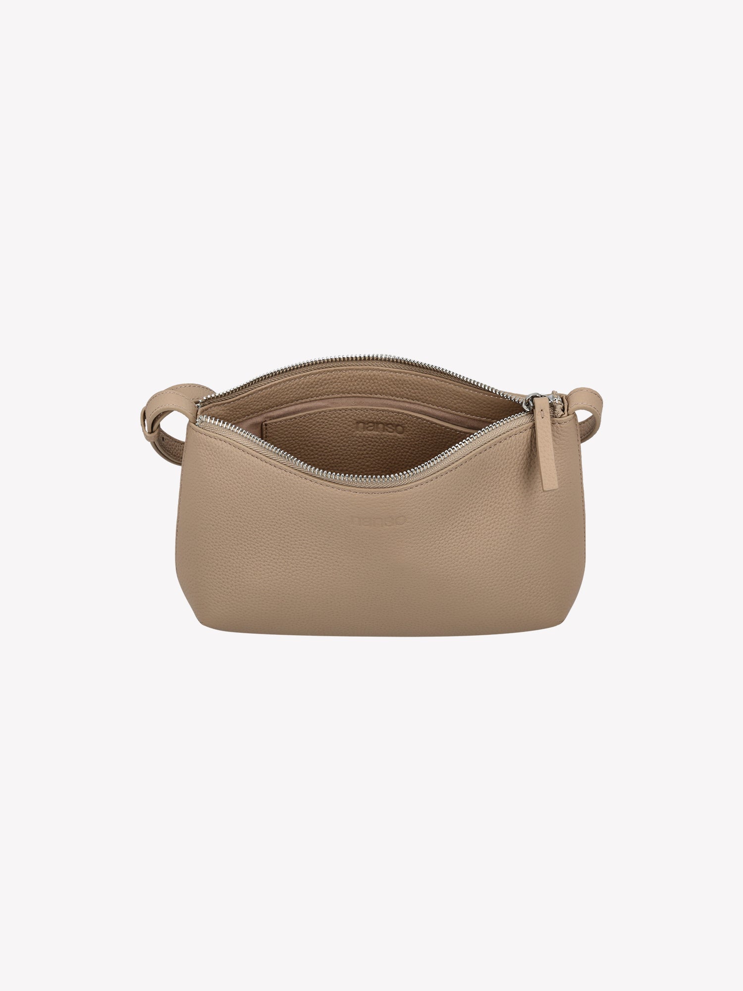 Nanso sleek light beige Naru leather bag comes with a long, adjustable shoulder strap and a secure zip closure. Made from certified leather. Product picture with a view to the inside of the bag.