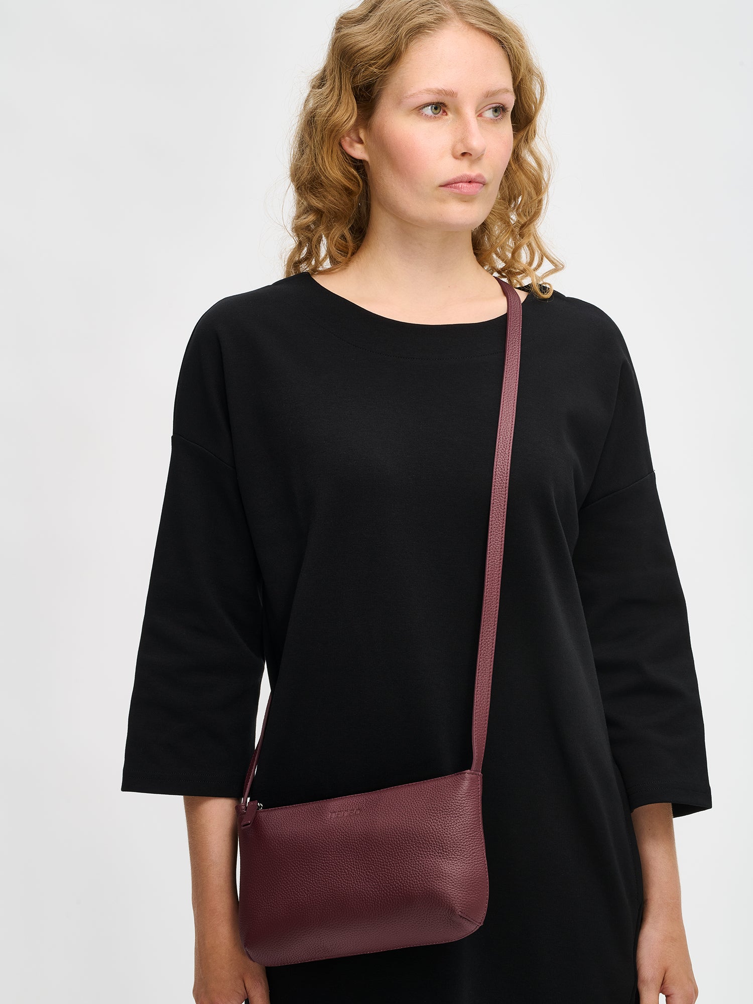 Nanso sleek burgundy Naru leather bag comes with a long, adjustable shoulder strap and a secure zip closure, front