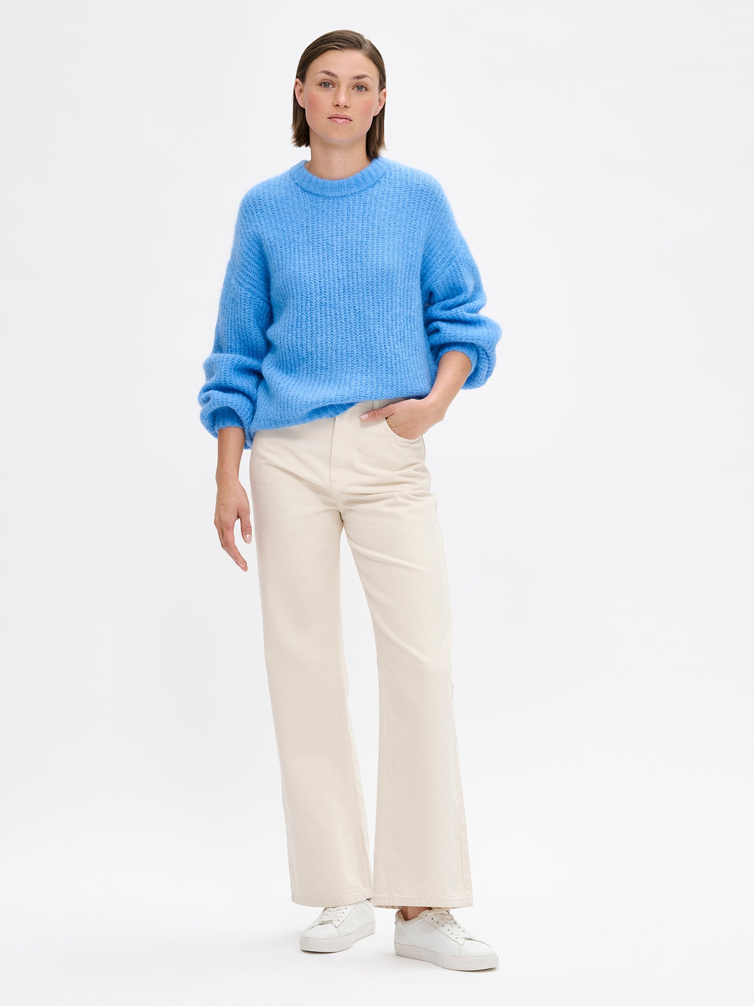 KARAMELLI women's luxurious mohair blend Knit Sweater in blue shade features a round neckline and full-length sleeves. Pictured on a model with jeans.