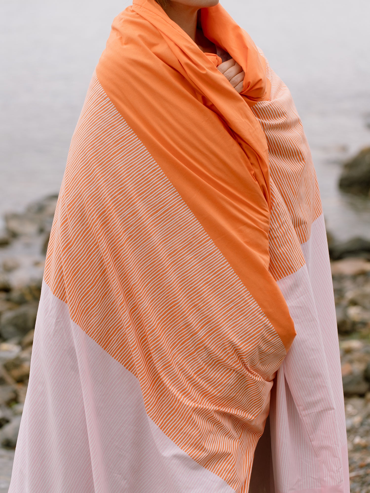 Nanso home's Viiru duvet cover set in orange, on person.