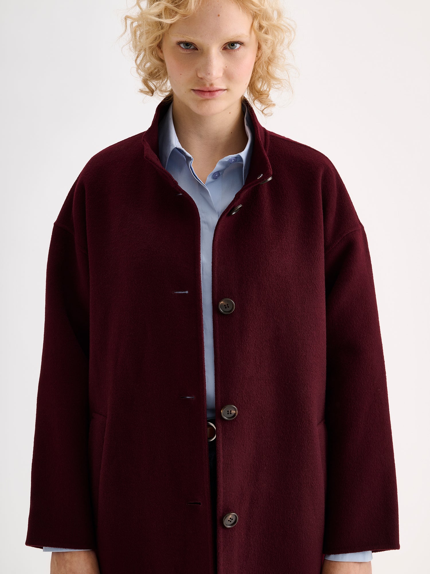 Nanso women's long burgundy Elle wool coat on a blonde model close-up
