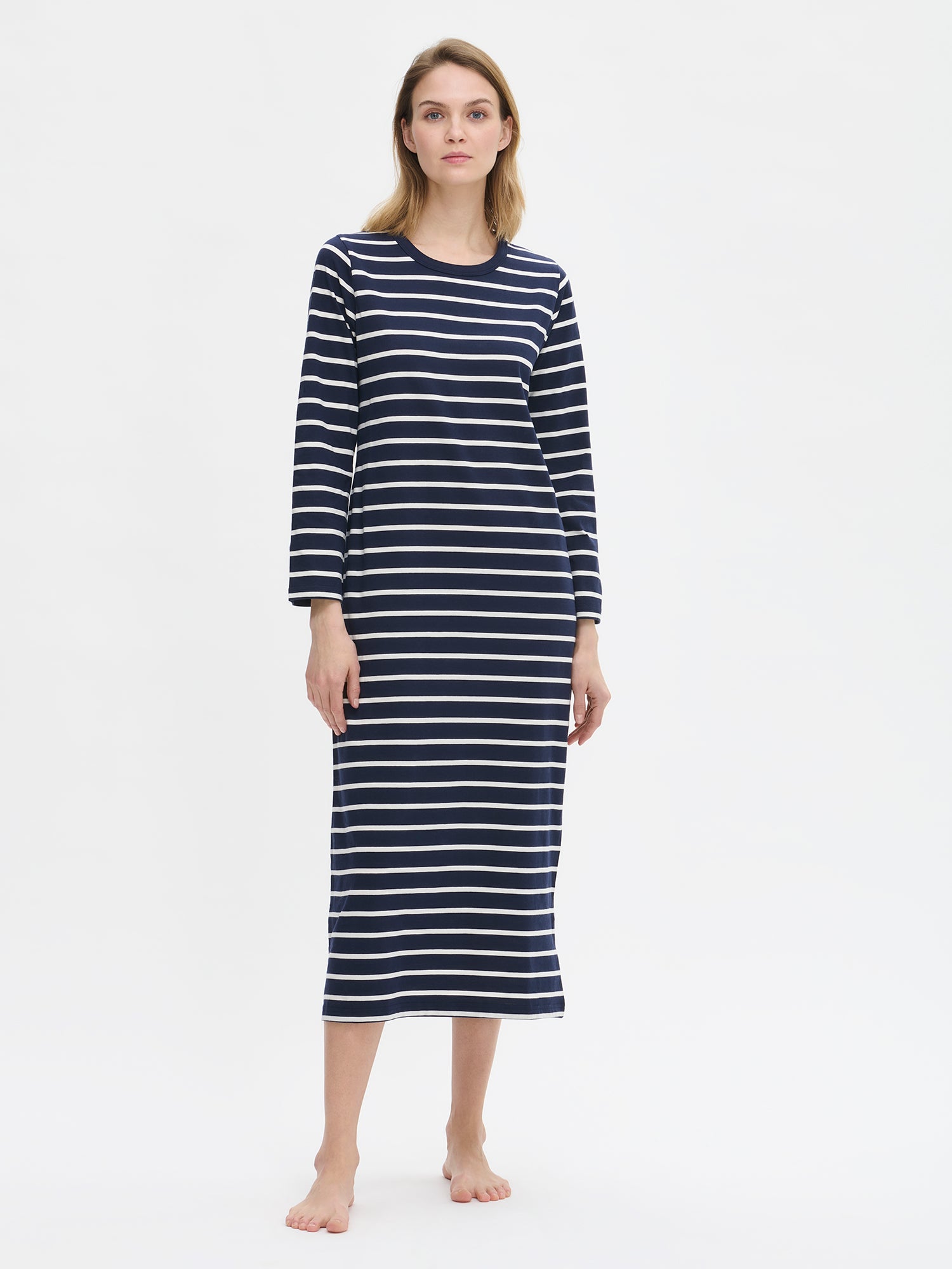 Women’s long Duetto nightgown with blue and white stripes has full-length sleeves and a round neckline as shown on a model in the picture.