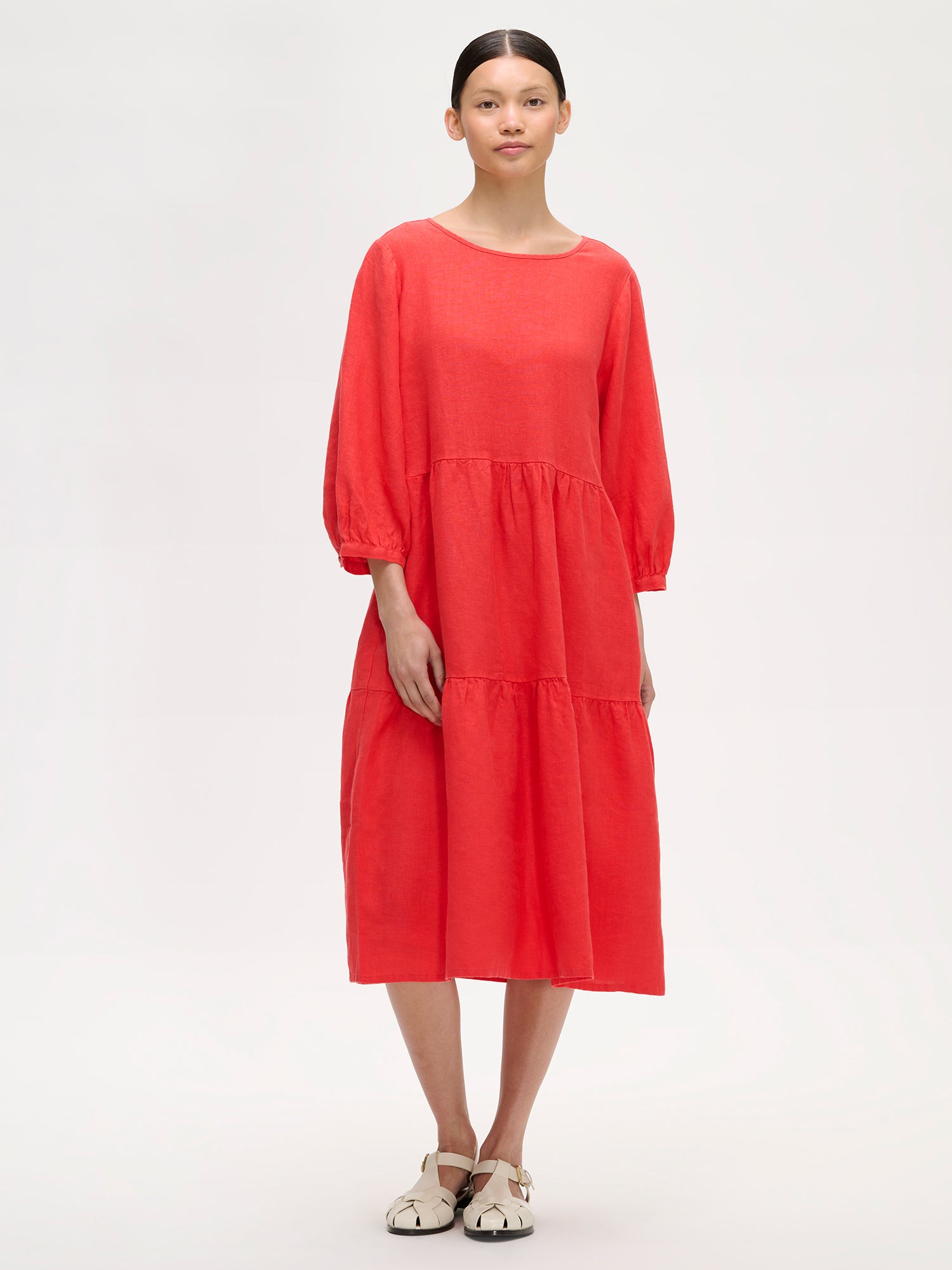 Women's Saralia Linen Dress in red with voluminous frill layers on amodel with sandals.
