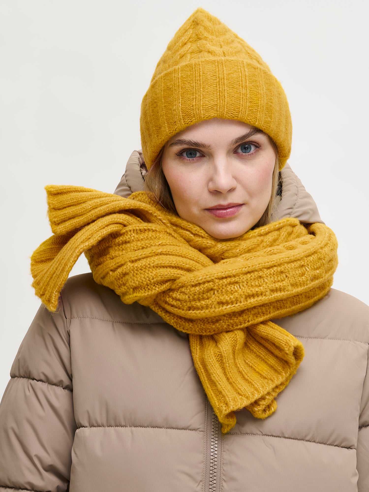 Nanso women’s yellow Kierre knit beanie features a charming cable pattern and a cozy, voluminous fit