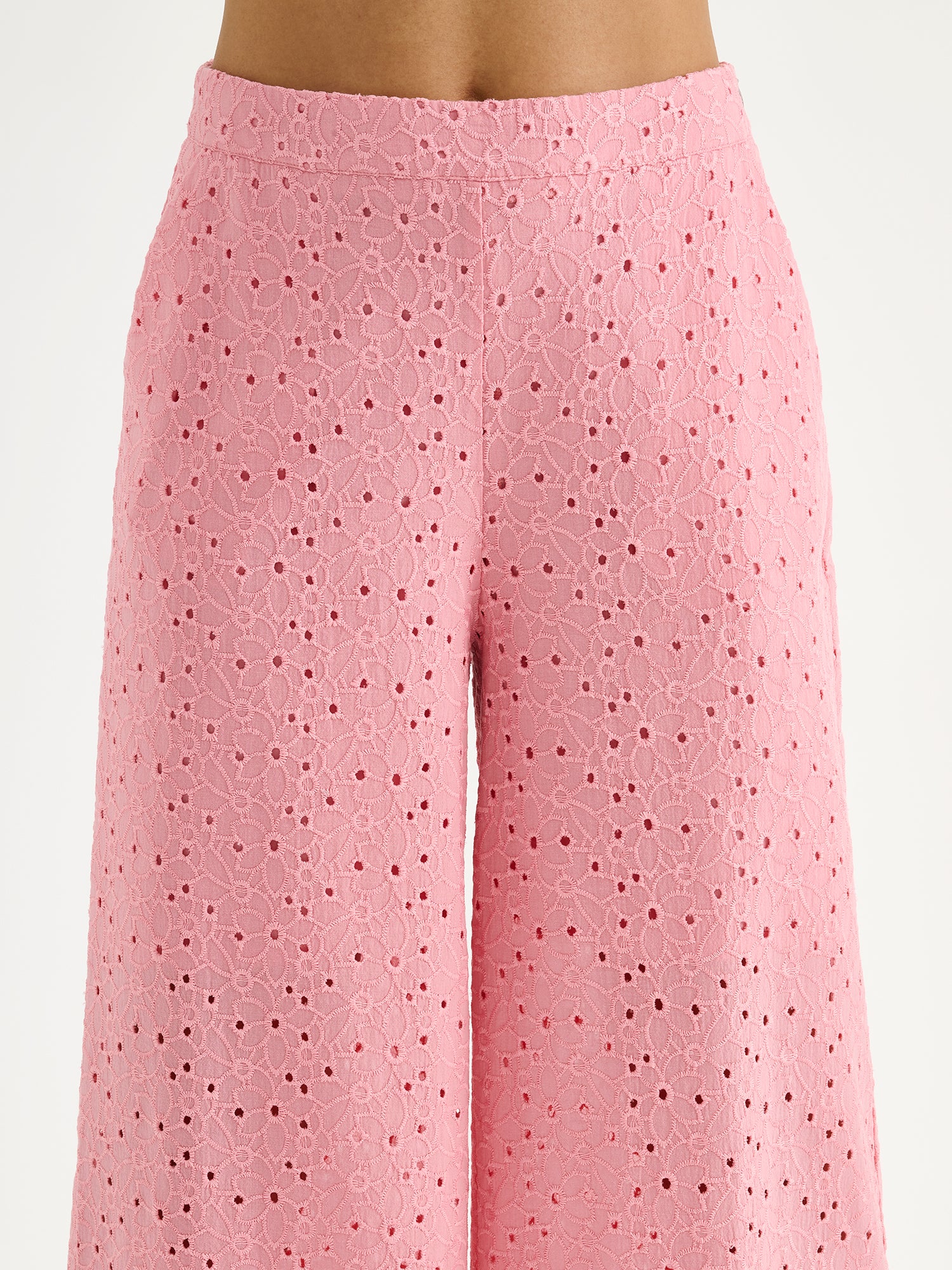 Nanso women's light pink embroidered Nuppu trousers with a broderie anglais style lace fabric on a model close-up.