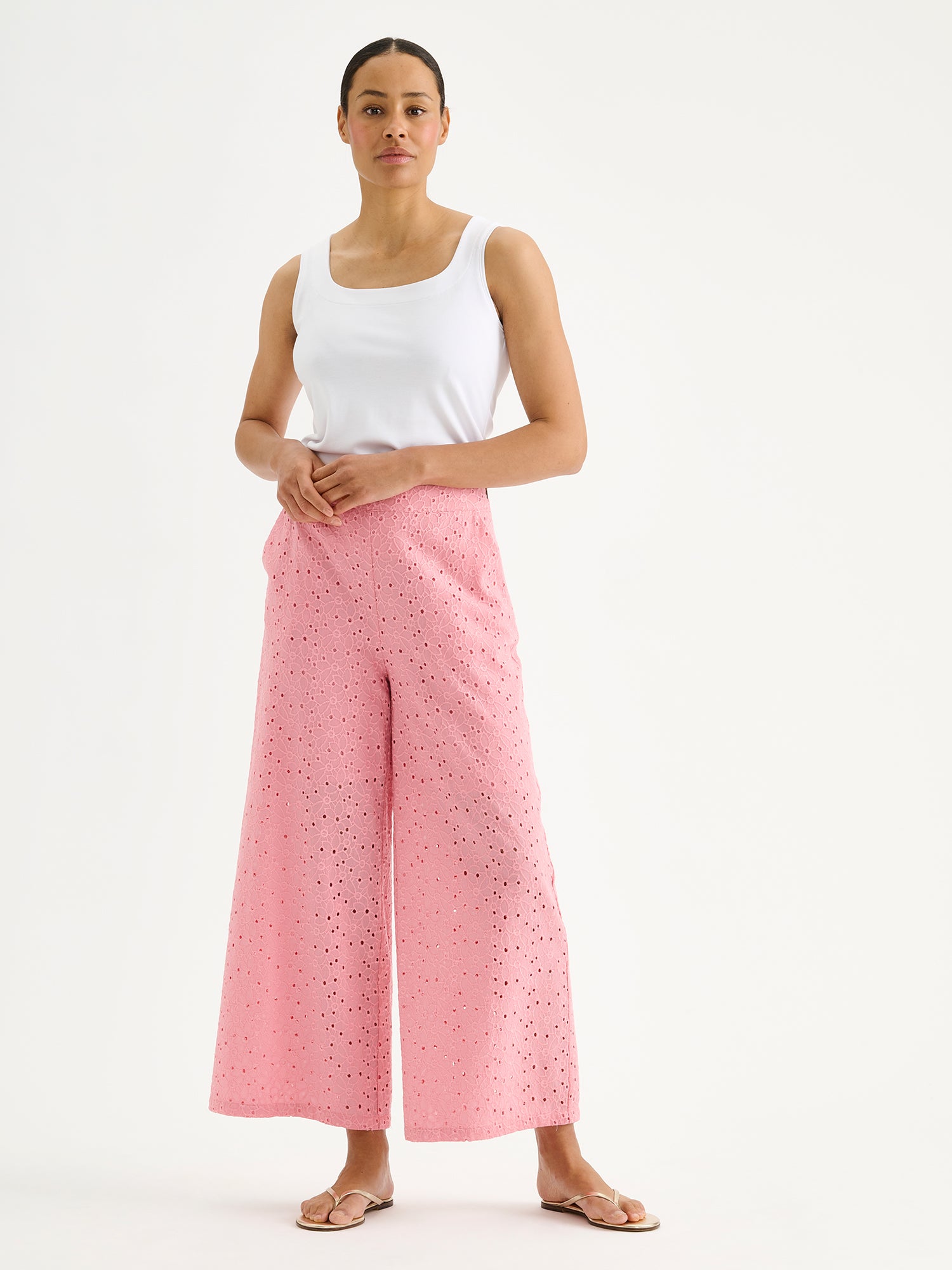 Nanso women's light pink embroidered Nuppu trousers with a broderie anglais style lace fabric on a model with a white top.
