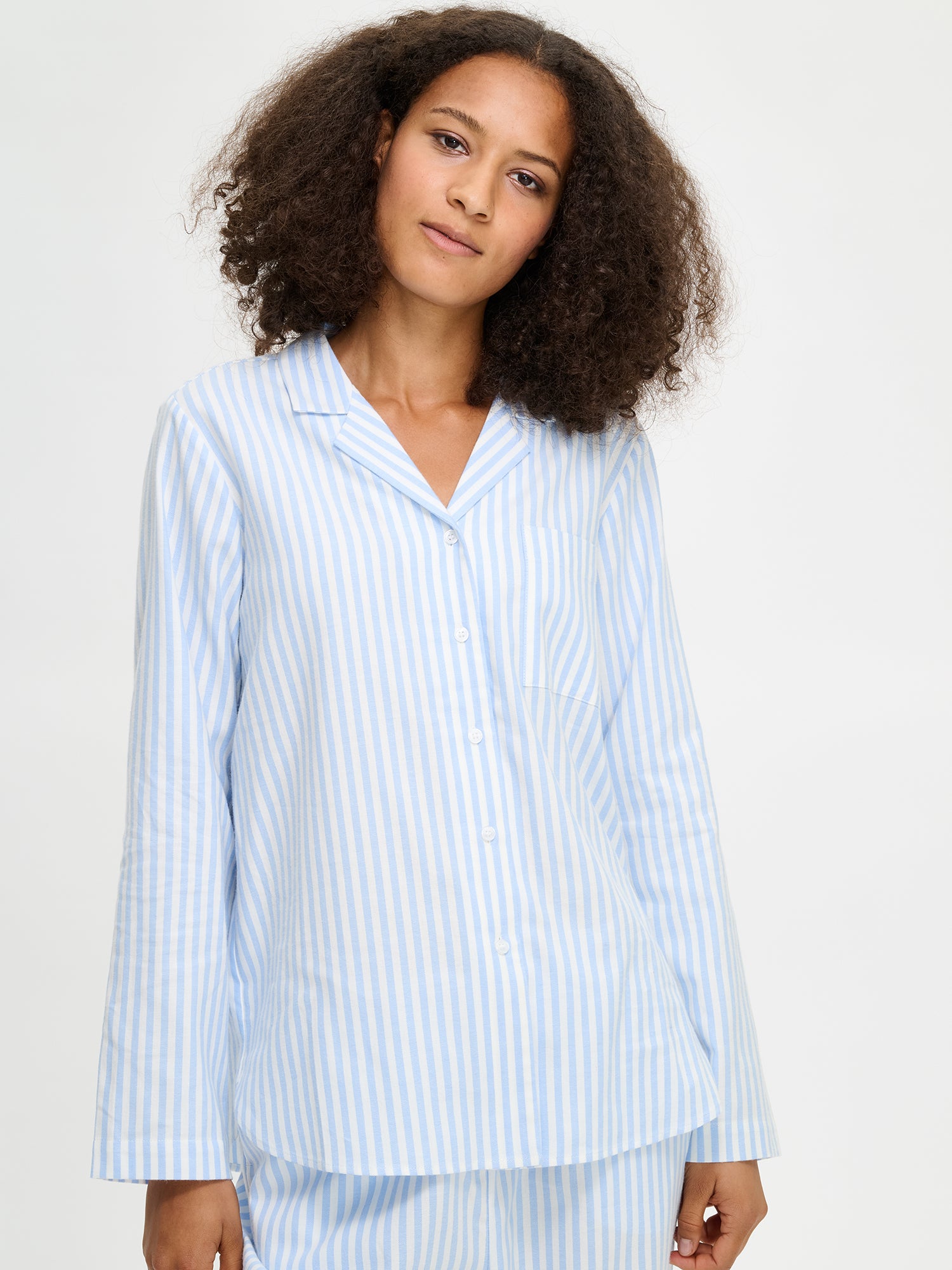 Women's striped Polka pajama shirt in light blue on a model in a close-up picture.