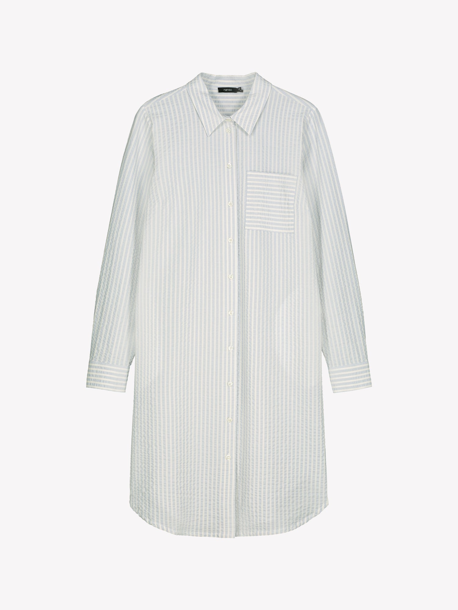 Nanso women's MAREA shirt dress in pale blue features a classic collar, front button closure, rounded hemline. A chest pocket and side pockets add everyday functionality. Product picture from the front.