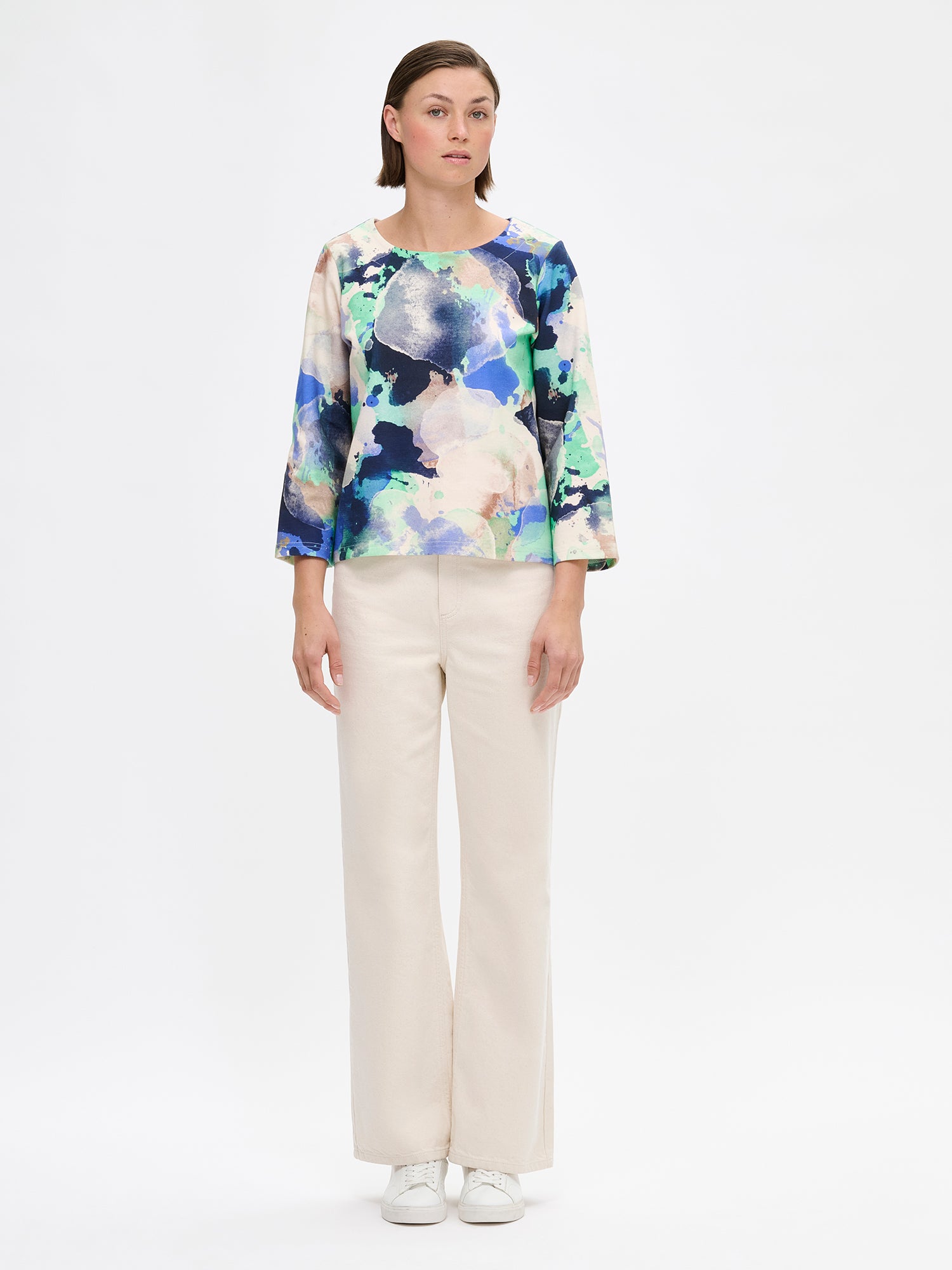 Women's SIRIUS Blouse features a beautiful abstract pattern and relaxed, boxy silhouette, a classic round neckline and 3/4 length sleeves. Pictured on a model with jeans.
