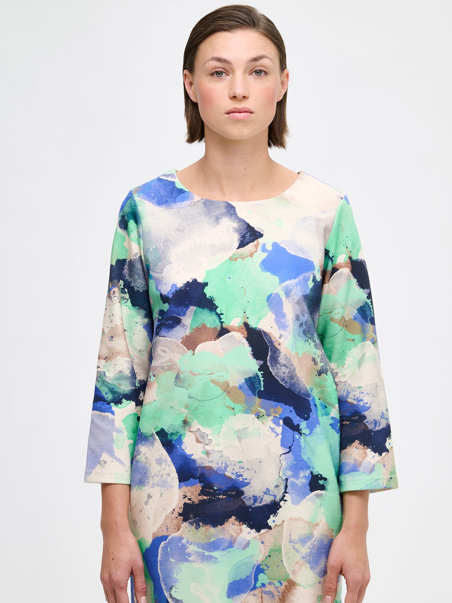 Women's SIRIUS Dress with a beautiful abstract pattern and a clean, minimalist cut that lets the beautiful pattern take center stage. The dress features 3/4 sleeves and pockets. Pictured on a model, close-up.