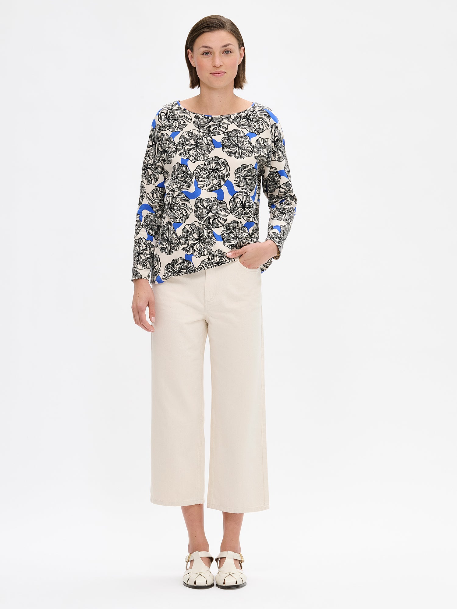 Nanso women's relaxed, patterned Pieni Kosmo blouse. The boxy blouse features a neckline finished with binding and full-length sleeves. The shoulder line is generously dropped. On a model with jeans.