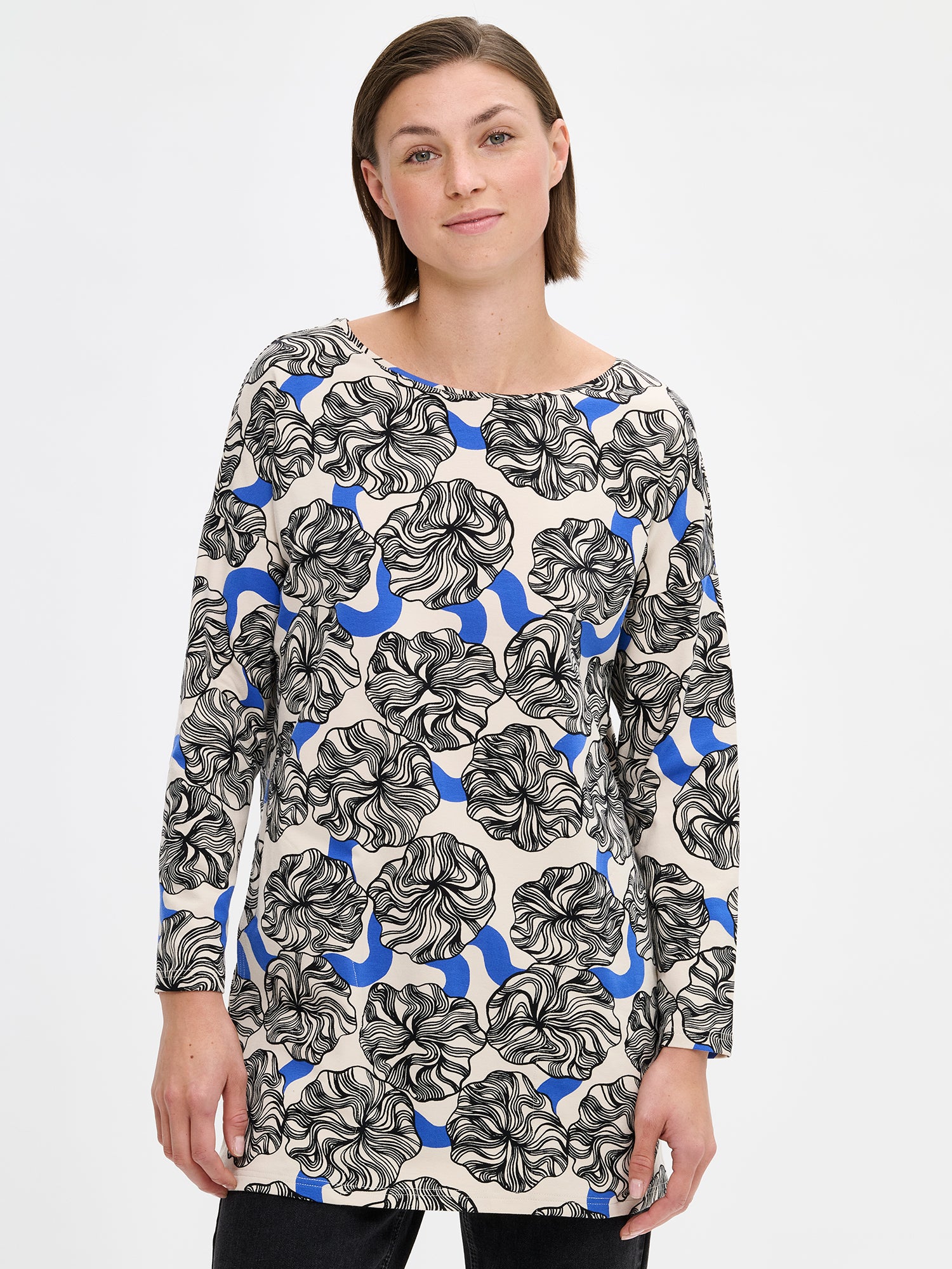 Nanso women's versatile, patterned Pieni Kosmo tunic. The straight-cut tunic features a dropped shoulder line, side pockets, and full-length sleeves. On a model with jeans, close-up