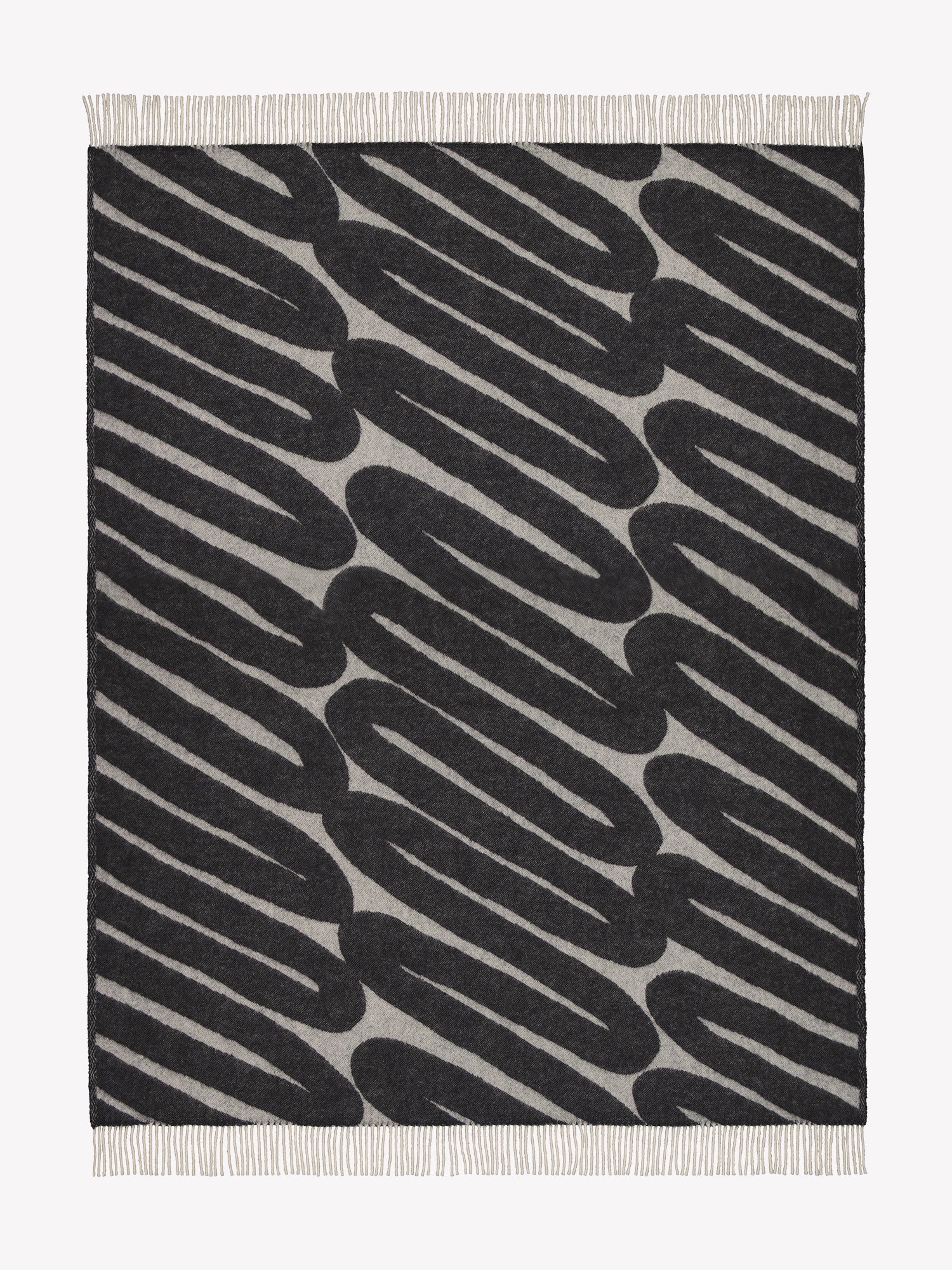 Laskos blanket in black with a striking graphic pattern and twisted fringes on the shorter sides opened in a product picture.