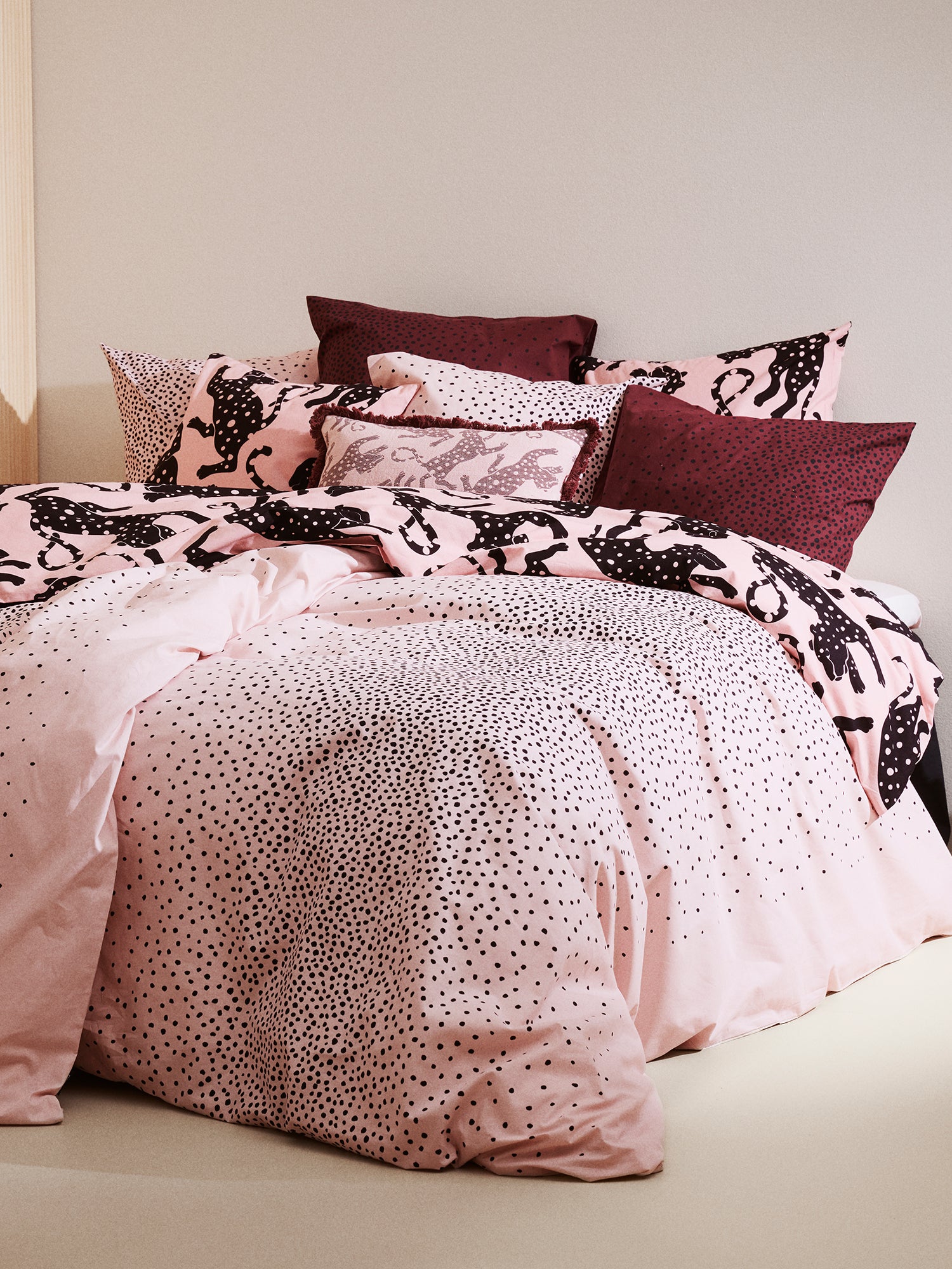 The rose Täplä duvet cover set placed on a bed with brown Täplä pillow cases.