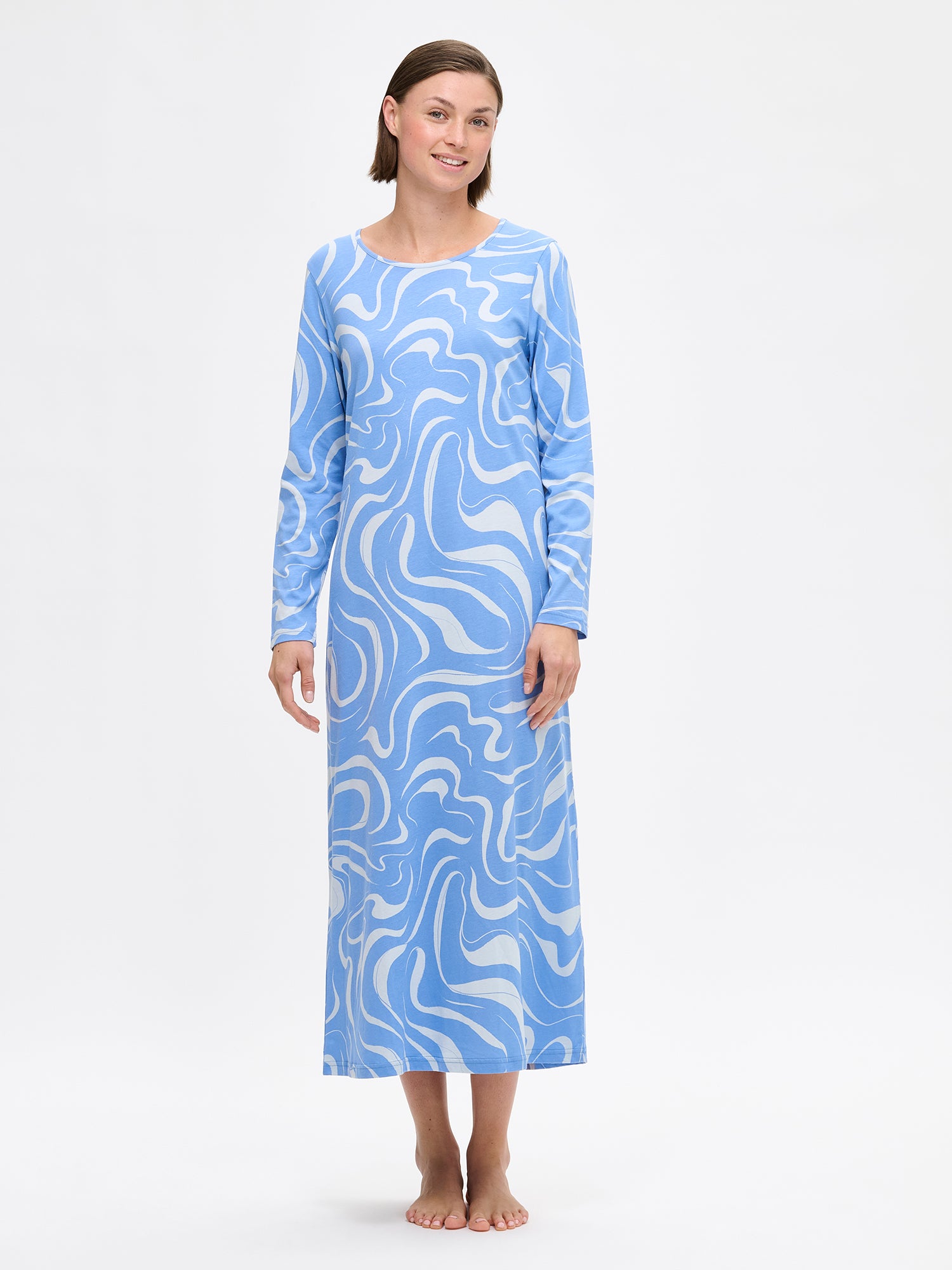 Nanso VESI long-sleeved nightgown blue tones with an elegant patterned design. Features a classic round neckline and relaxed fit and soft material for restful nights. On a model from the front.