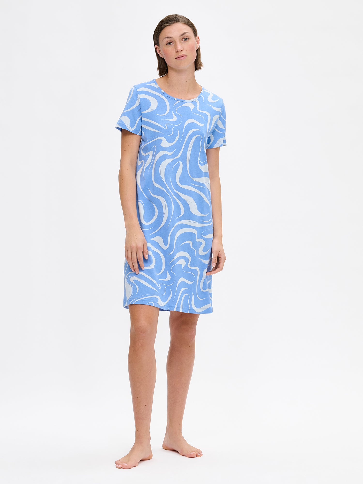 Nanso VESI short nightgown in blue tones with an elegant patterned design. Features a classic round neckline and relaxed fit and soft material for restful nights. On a model from the front.