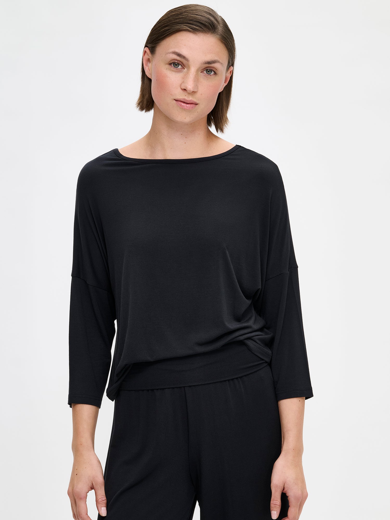 The HENTO 3/4 Sleeve Shirt delivers understated elegance in a luxuriously soft, silk-like fabric. It features gently tapered kimono sleeves and a refined neckline. On a model, close-up.