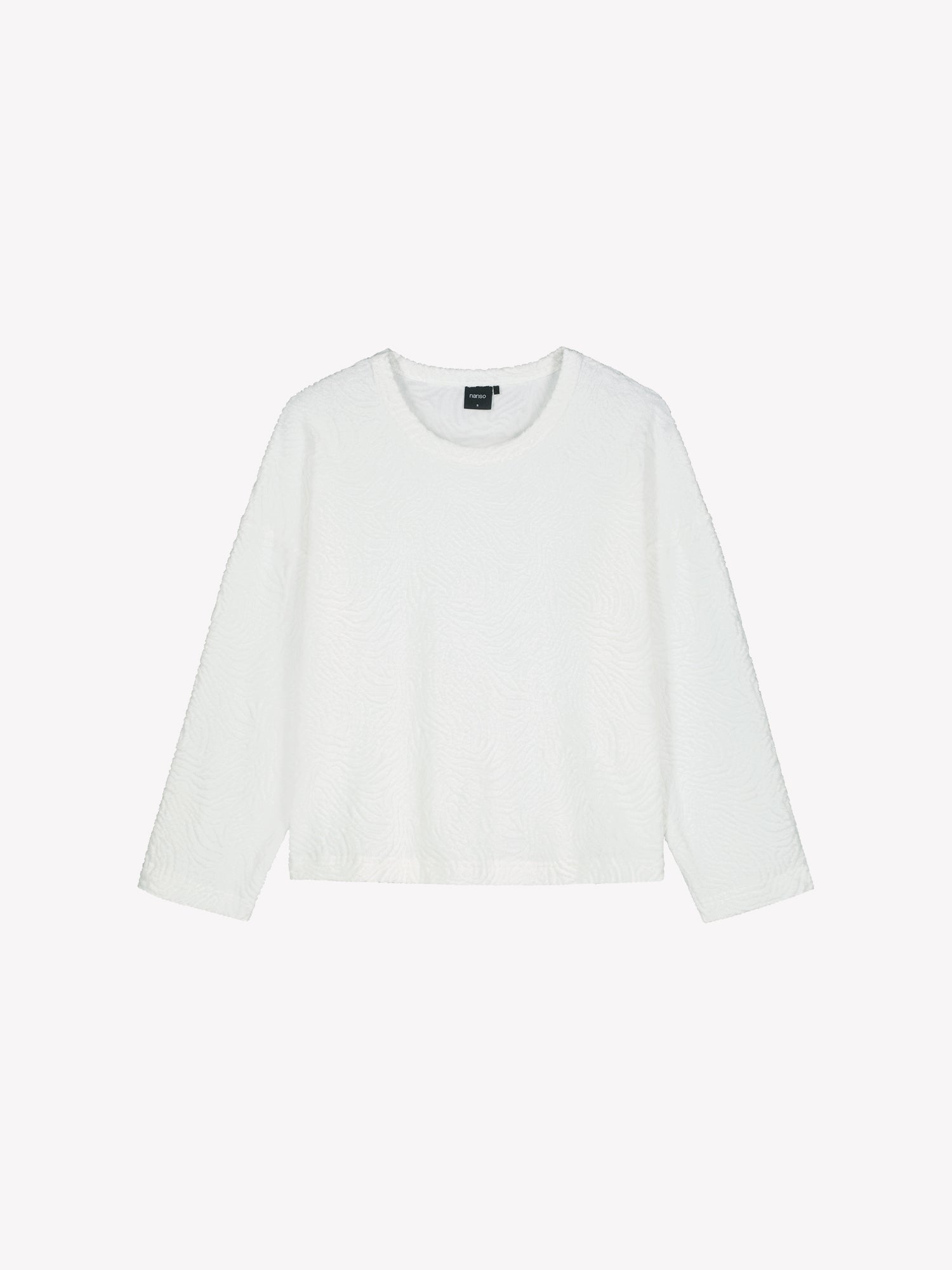 The VÄRE Shirt in off-white features long sleeves and a classic round neckline and a beautifully textured jacquard knit fabric, designed for relaxed comfort. Product picture from the front.