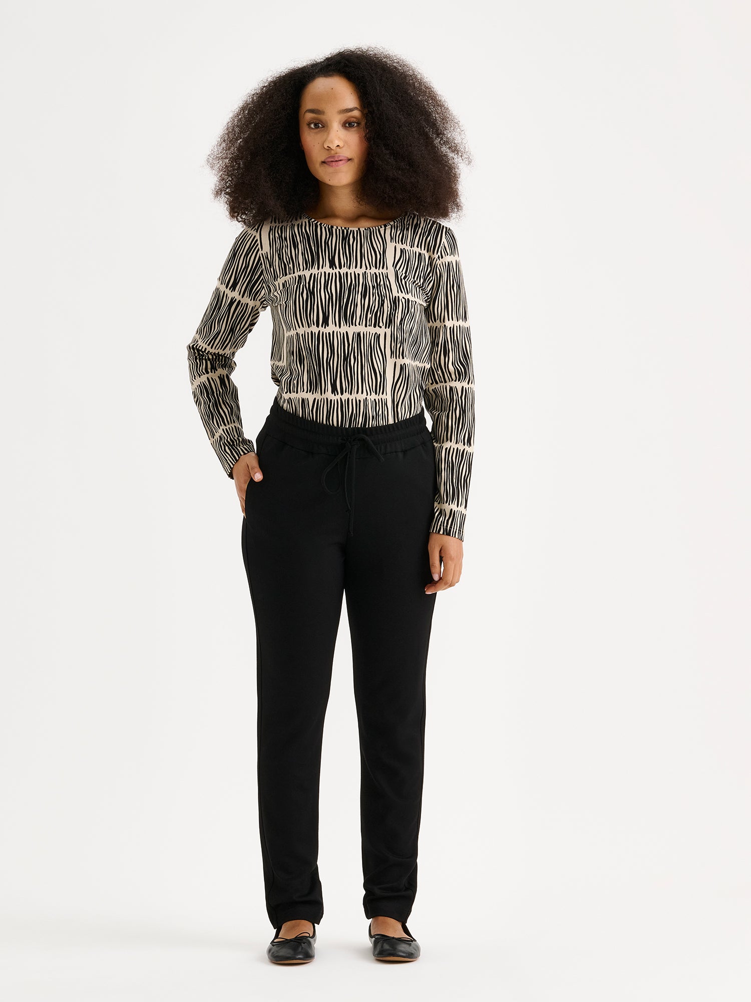 Nanso women's Ruoko jersey blouse on a model with black trousers.