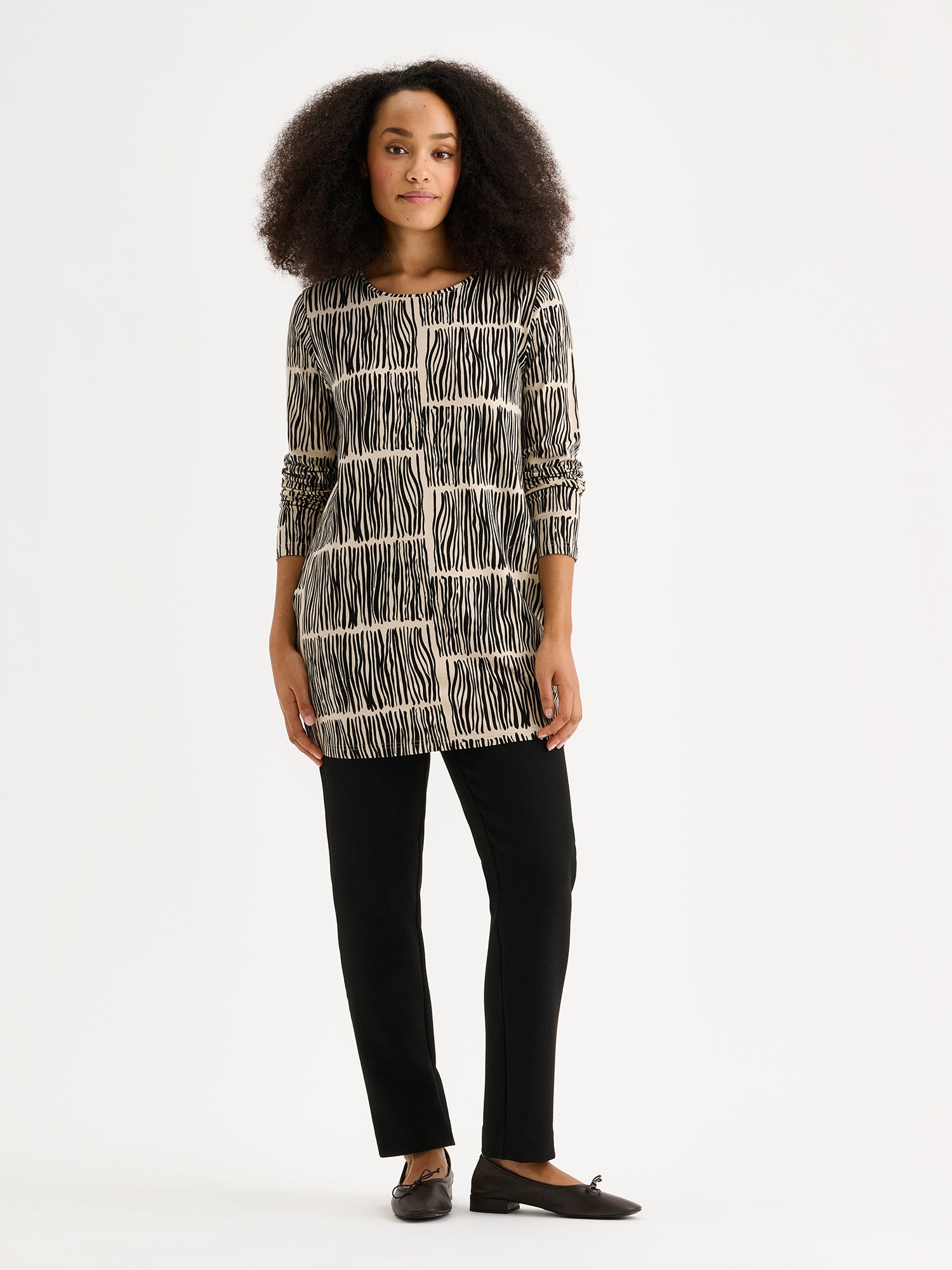 The RUOKO Jersey Tunic combines everyday comfort with understated elegance, on a model with black trousers.
