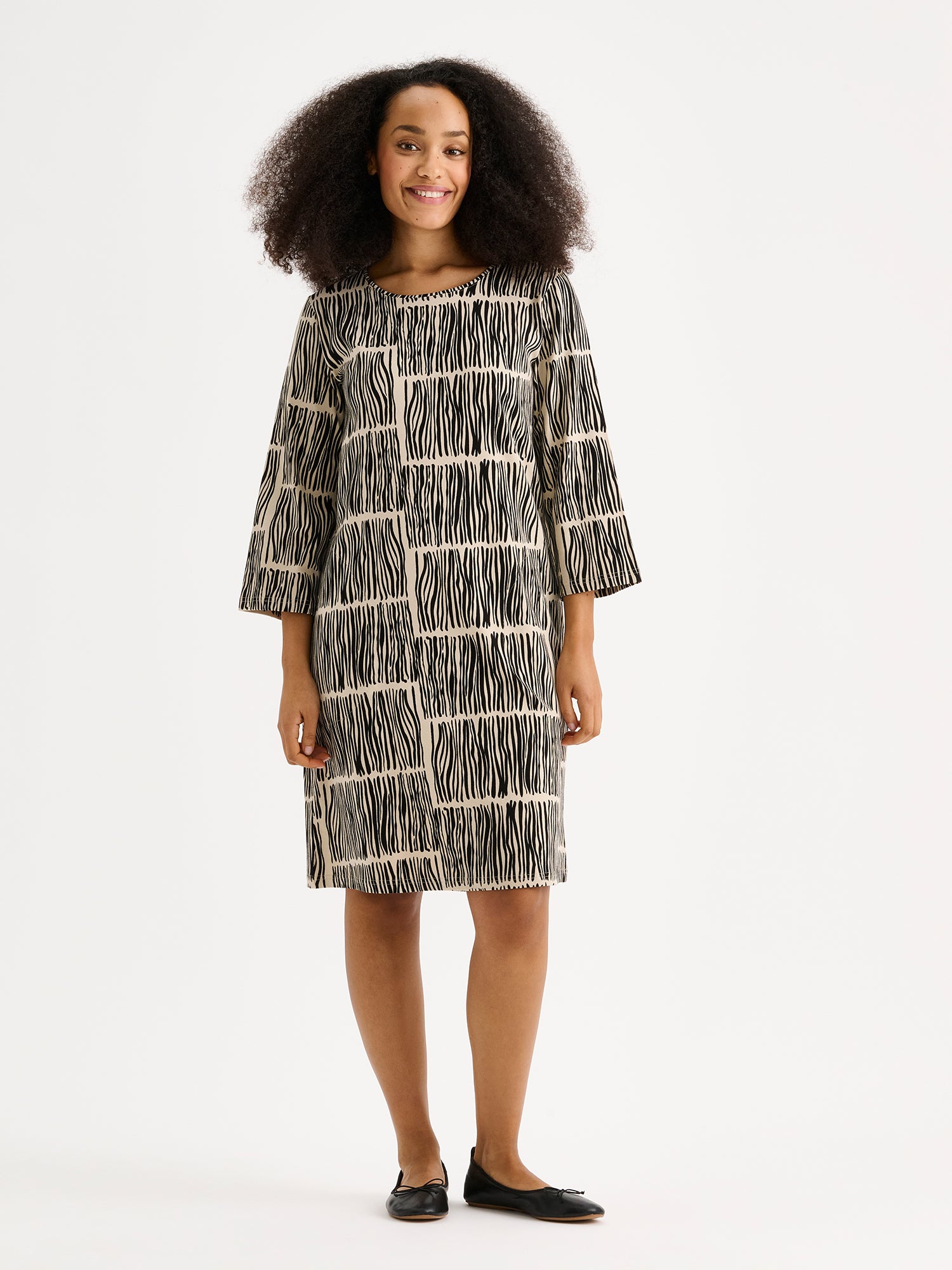 The Ruoko jersey dress on a model with black ballerinas.