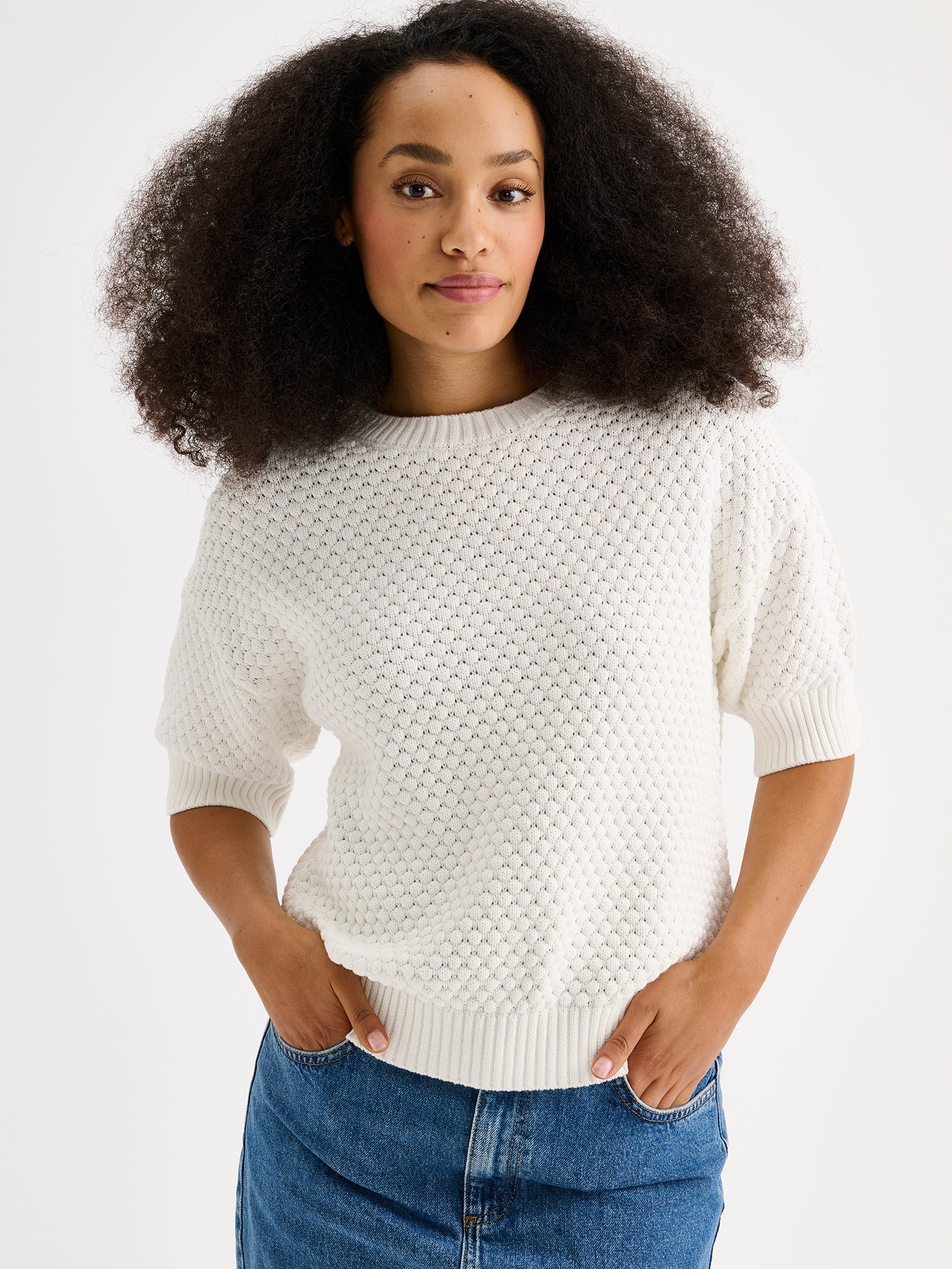 Nanso women's Kumpu versatile short-sleeved knit sweater in off white on a model with denim skirt, close-up